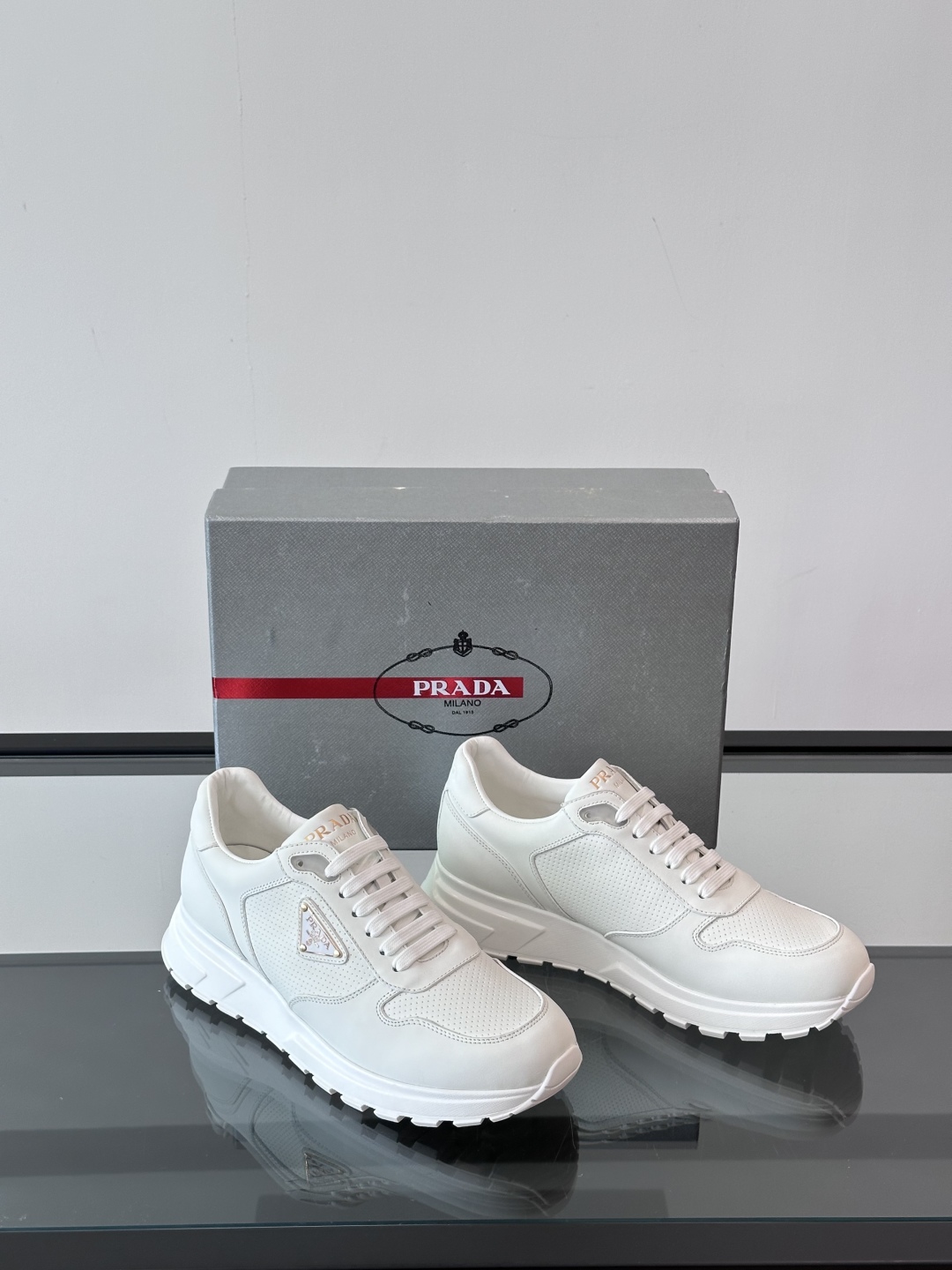 Prada/普拉达 男士新款运动休闲鞋，这款运动鞋鞋面采用进口小牛皮。外侧饰以P家经典金属三角珐琅徽标，
