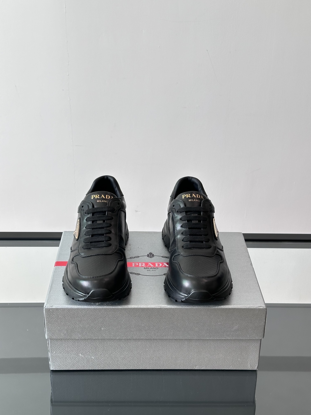 Prada/普拉达 男士新款运动休闲鞋，这款运动鞋鞋面采用进口小牛皮。外侧饰以P家经典金属三角珐琅徽标，