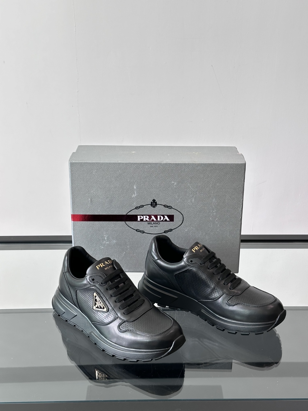 Prada/普拉达 男士新款运动休闲鞋，这款运动鞋鞋面采用进口小牛皮。外侧饰以P家经典金属三角珐琅徽标，