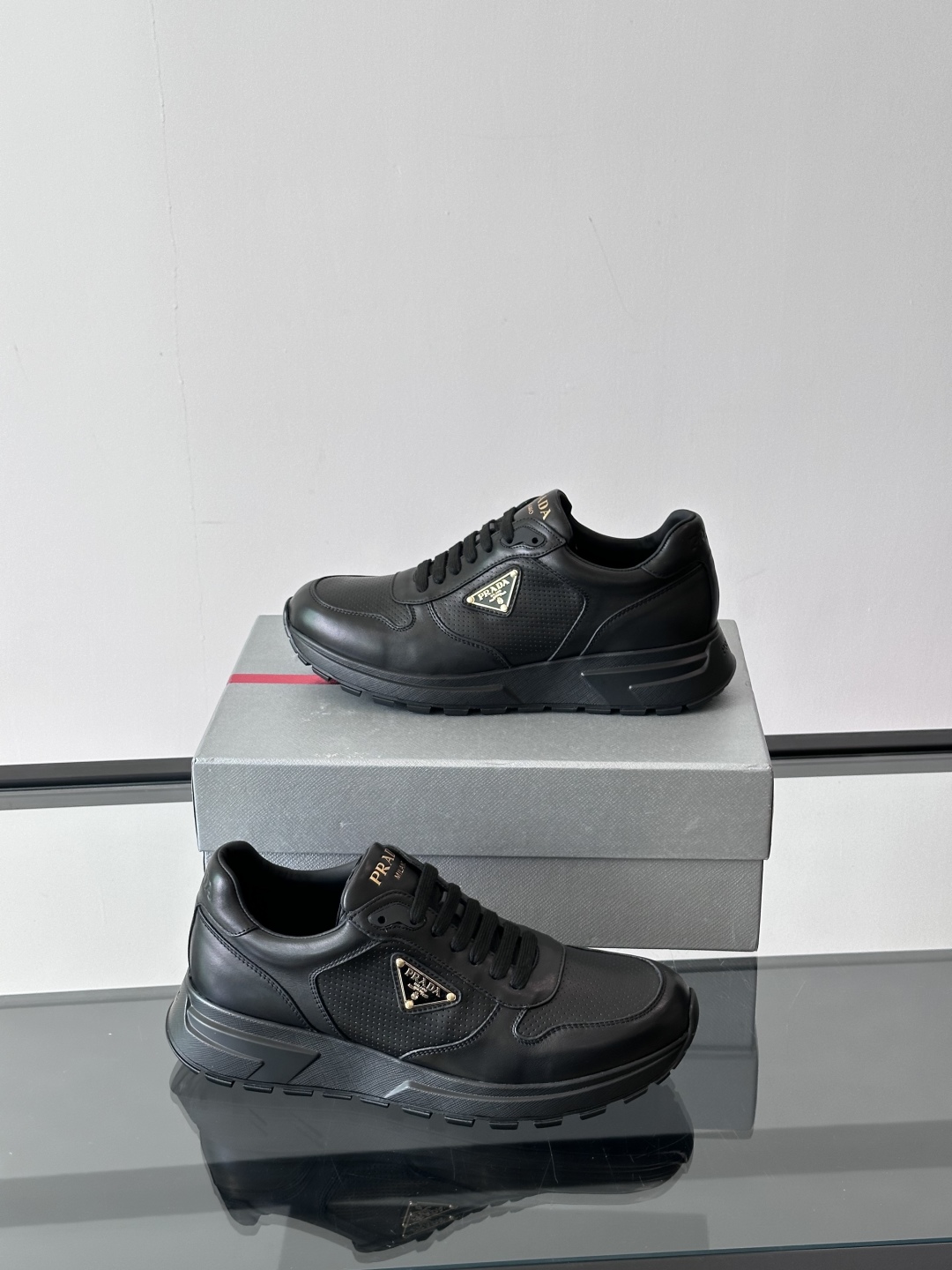 Prada/普拉达 男士新款运动休闲鞋，这款运动鞋鞋面采用进口小牛皮。外侧饰以P家经典金属三角珐琅徽标，