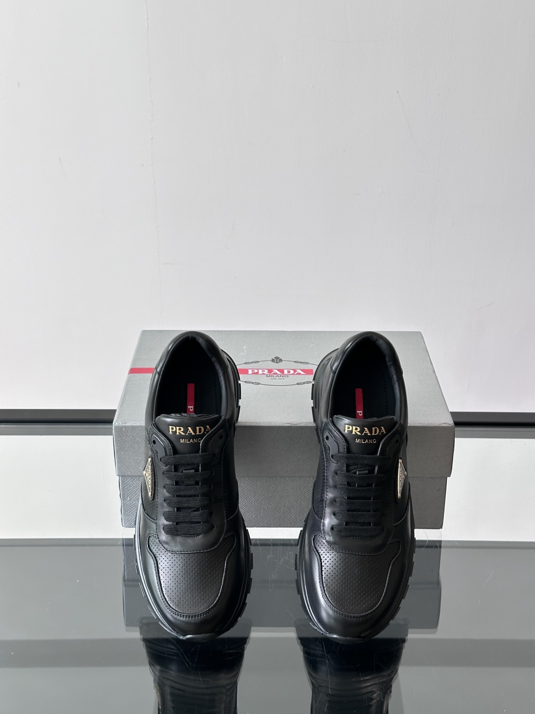 Prada/普拉达 男士新款运动休闲鞋，这款运动鞋鞋面采用进口小牛皮。外侧饰以P家经典金属三角珐琅徽标，