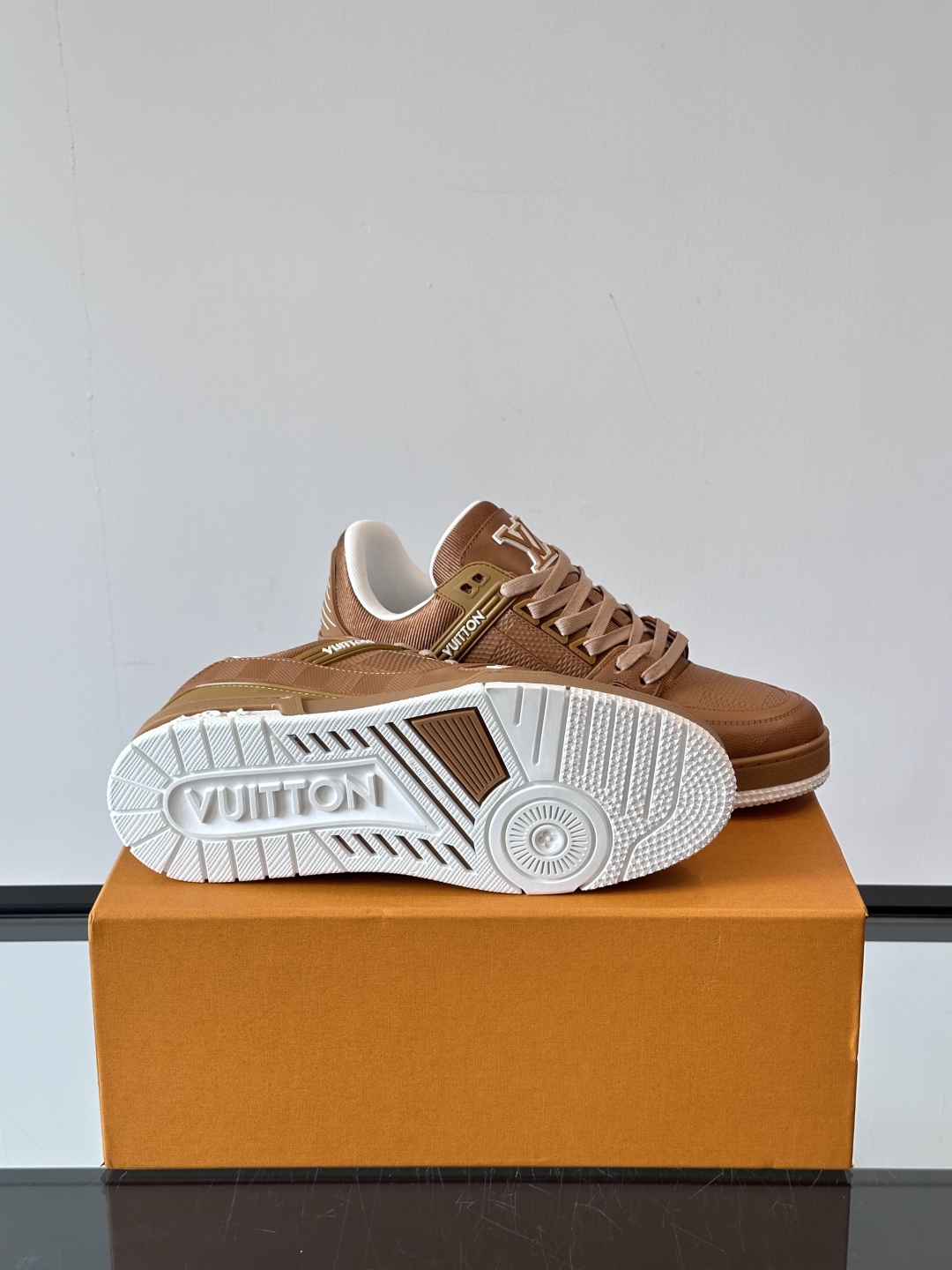  LV Trainer 运动鞋以柔软 Damier 压纹牛皮革续写经典设计。金属端头皮革鞋带点亮雅致鞋身