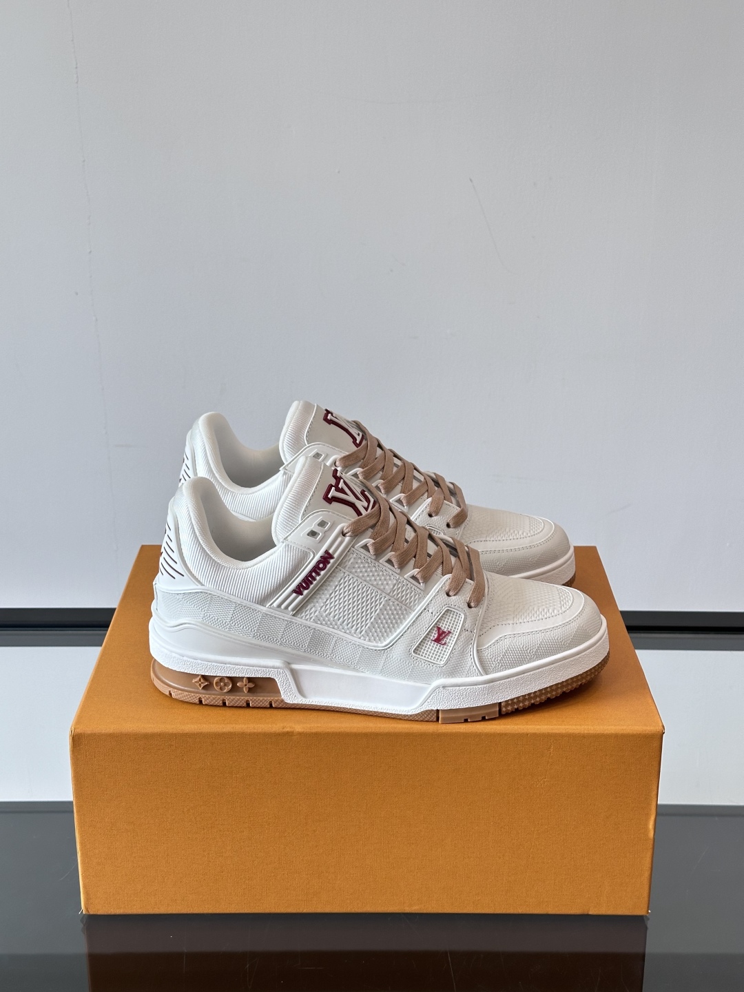  LV Trainer 运动鞋以柔软 Damier 压纹牛皮革续写经典设计。金属端头皮革鞋带点亮雅致鞋身