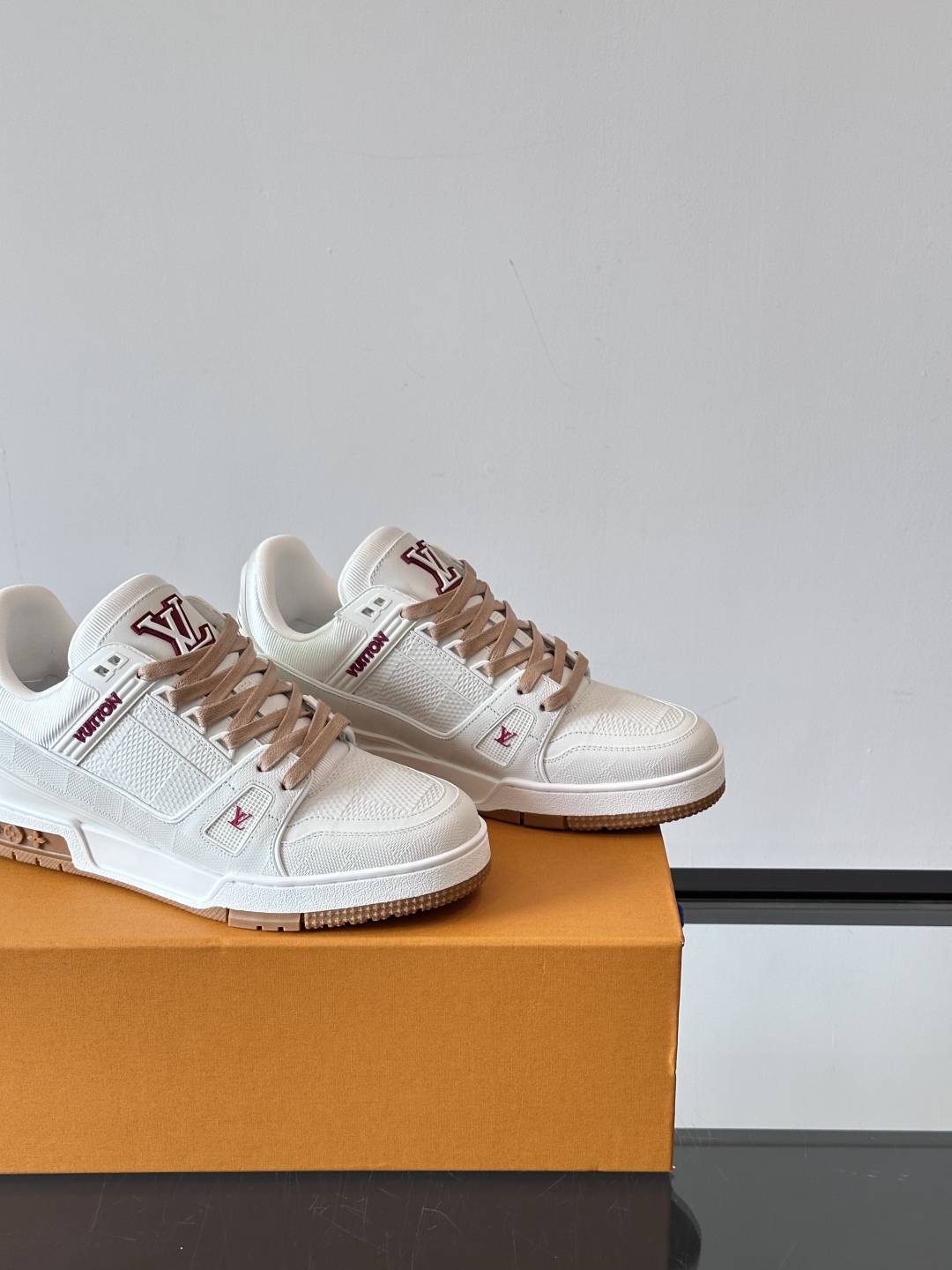  LV Trainer 运动鞋以柔软 Damier 压纹牛皮革续写经典设计。金属端头皮革鞋带点亮雅致鞋身