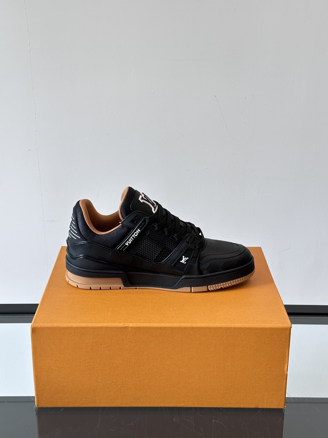  LV Trainer 运动鞋以柔软 Damier 压纹牛皮革续写经典设计。金属端头皮革鞋带点亮雅致鞋身