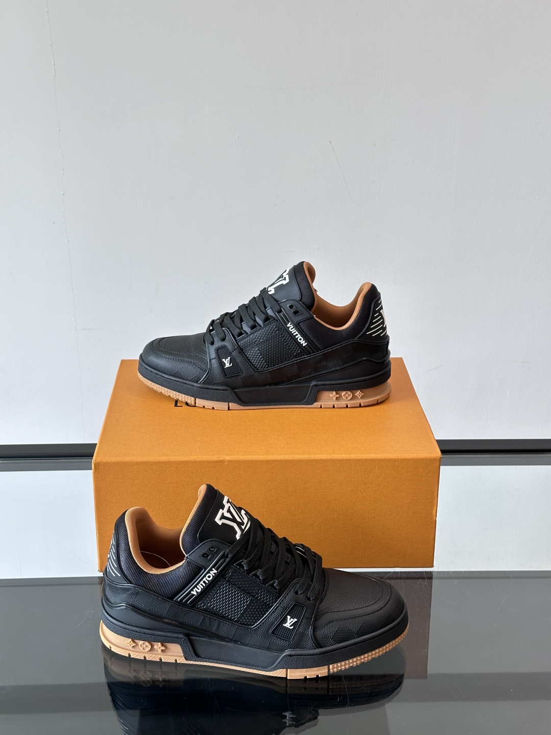  LV Trainer 运动鞋以柔软 Damier 压纹牛皮革续写经典设计。金属端头皮革鞋带点亮雅致鞋身