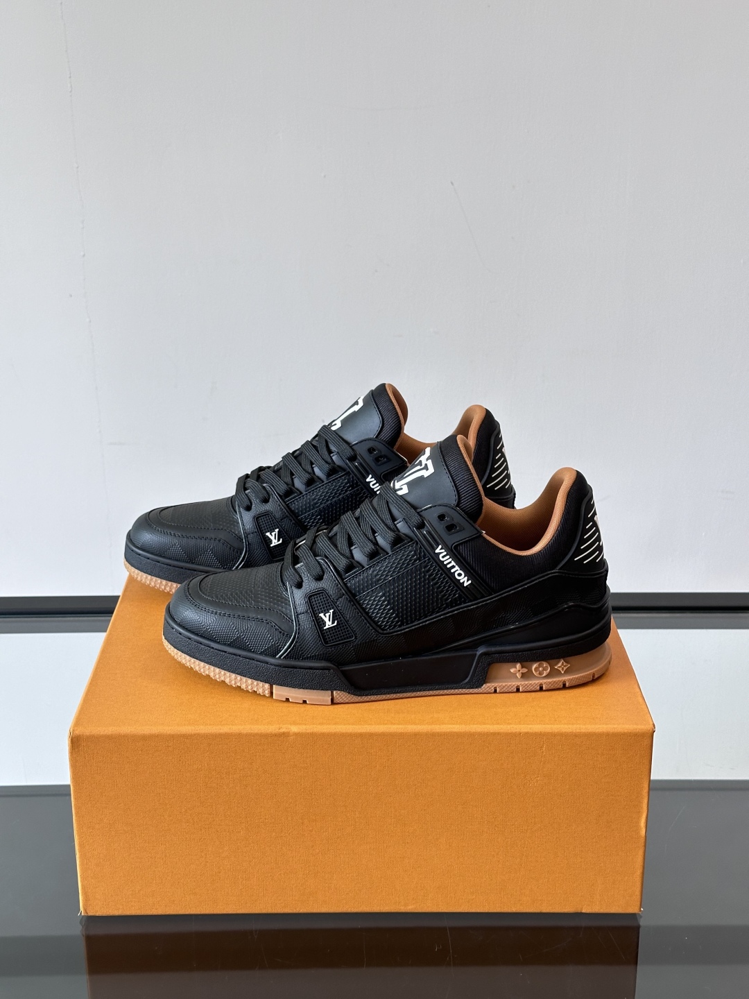  LV Trainer 运动鞋以柔软 Damier 压纹牛皮革续写经典设计。金属端头皮革鞋带点亮雅致鞋身