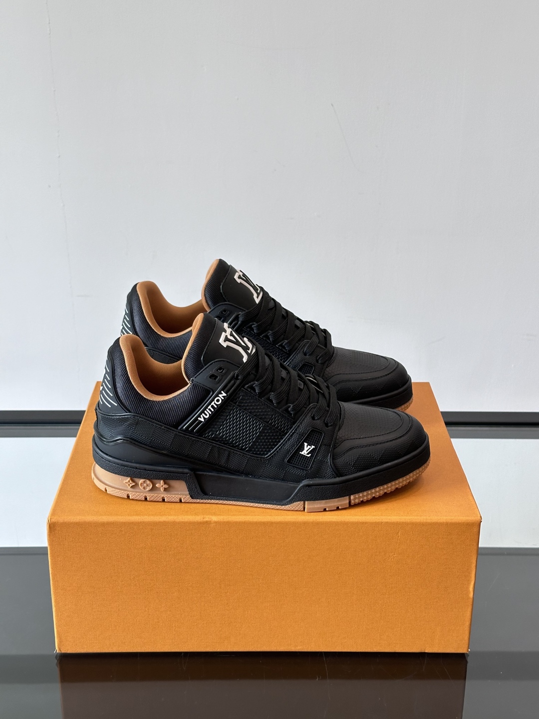  LV Trainer 运动鞋以柔软 Damier 压纹牛皮革续写经典设计。金属端头皮革鞋带点亮雅致鞋身