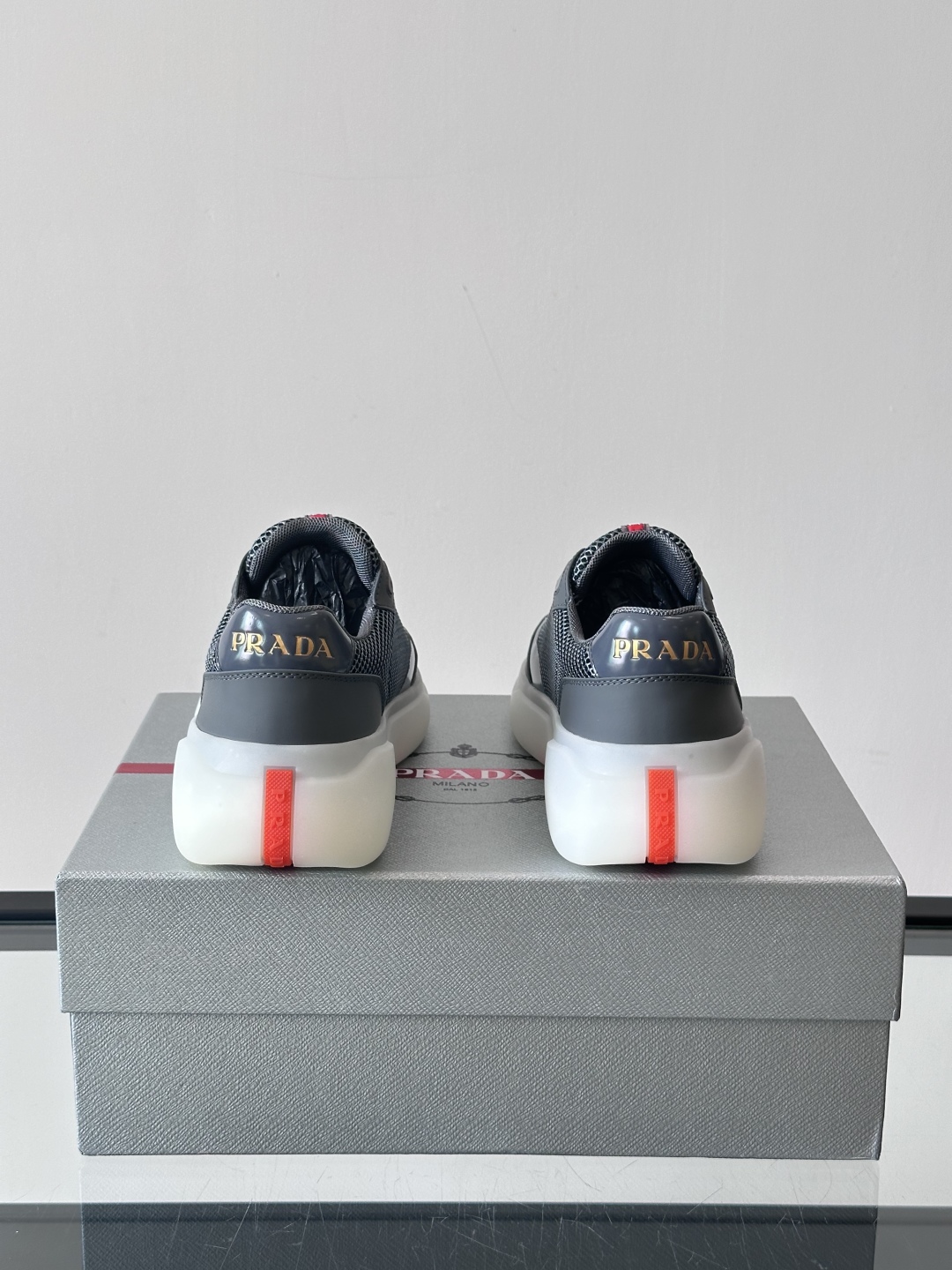 Prada/普拉达 男士新款运动休闲鞋，这款运动鞋鞋面采用进口小牛皮拼接透气网面，外侧饰以P家经典金属三