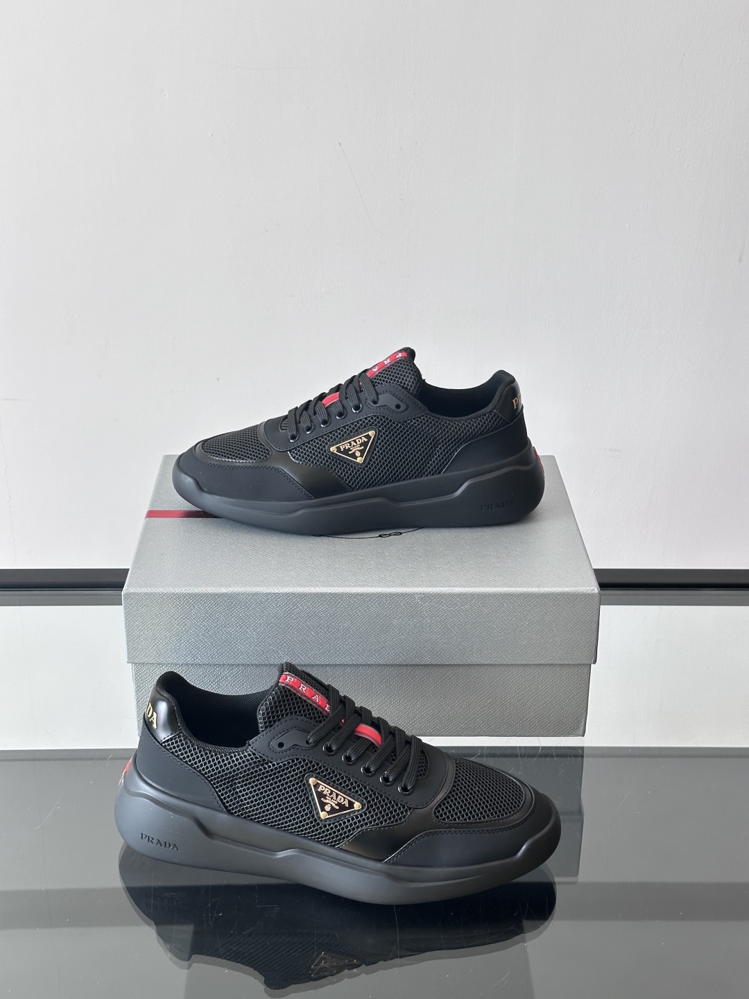 Prada/普拉达 男士新款运动休闲鞋，这款运动鞋鞋面采用进口小牛皮拼接透气网面，外侧饰以P家经典金属三