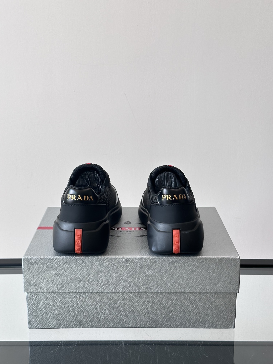 Prada/普拉达 男士新款运动休闲鞋，这款运动鞋鞋面采用进口小牛皮拼接透气网面，外侧饰以P家经典金属三