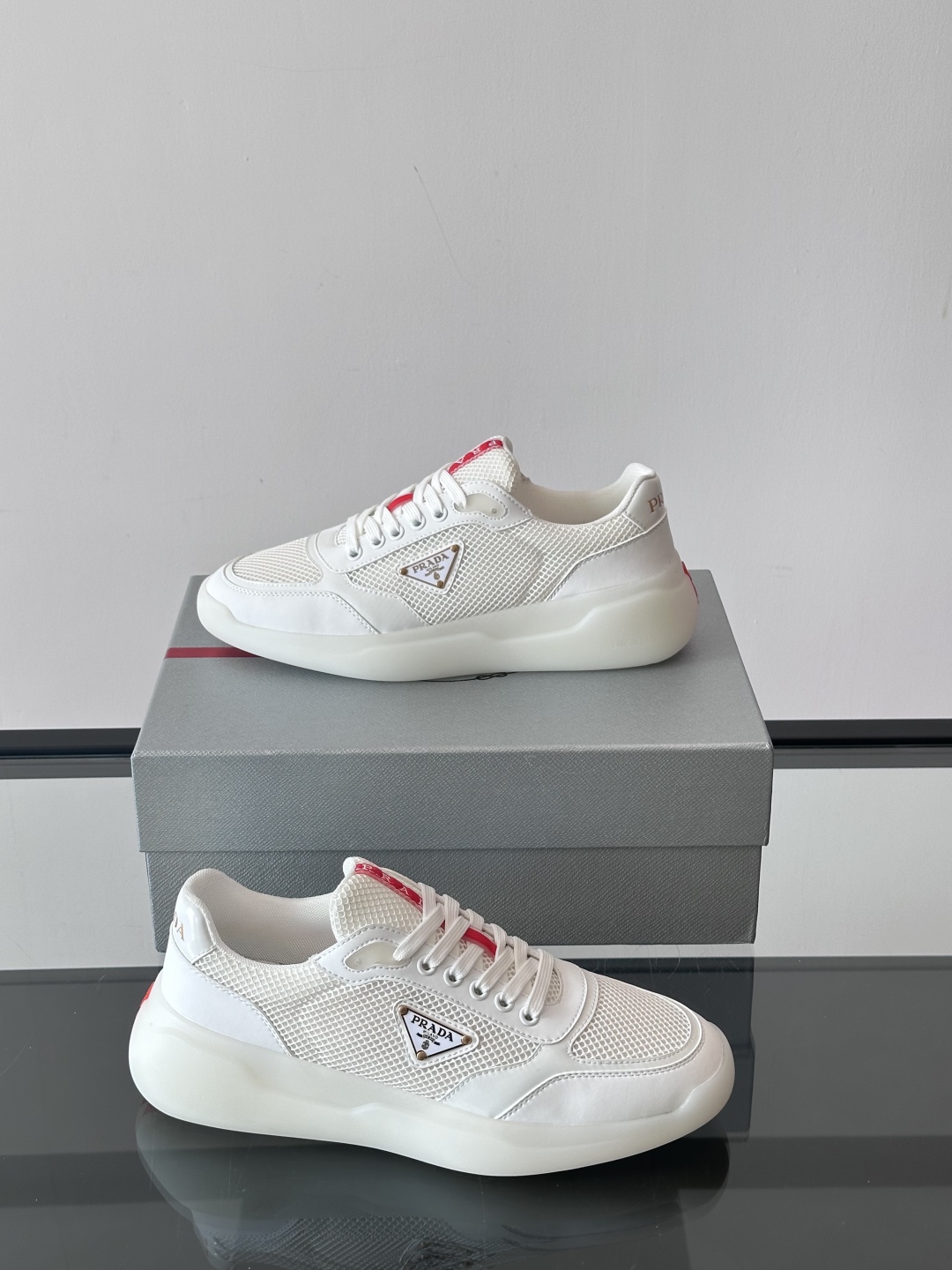Prada/普拉达 男士新款运动休闲鞋，这款运动鞋鞋面采用进口小牛皮拼接透气网面，外侧饰以P家经典金属三