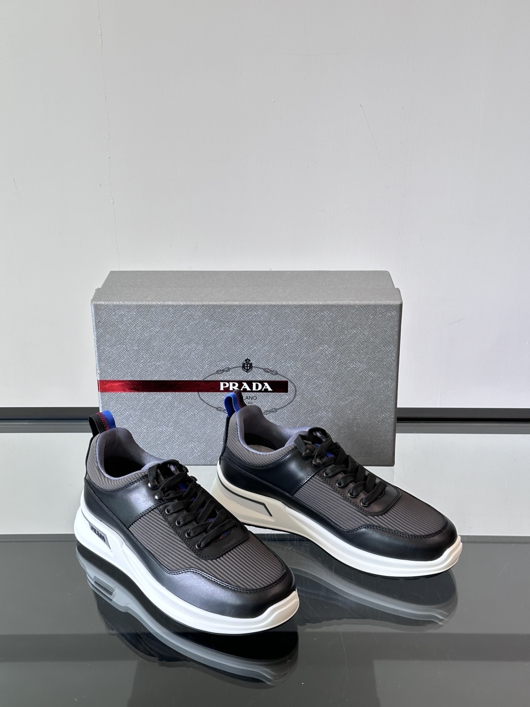 Prada/普拉达 男士新款运动休闲鞋，这款运动鞋鞋面采用进口小牛皮拼接透气网面，透气网面内里。垫脚牛皮