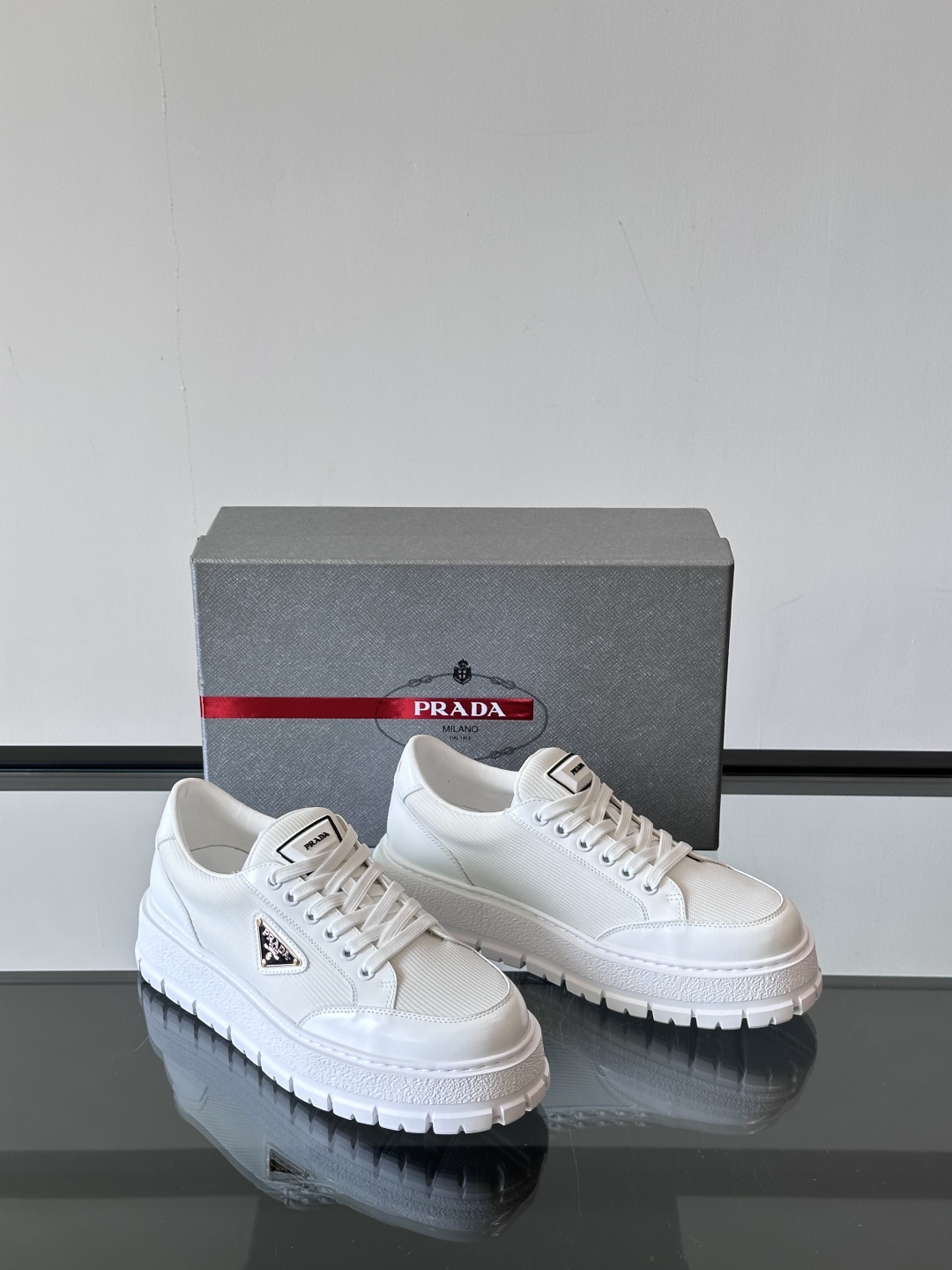 Prada/普拉达 男士新款运动休闲鞋，这款运动鞋鞋面采用进口小牛皮拼接透气网面，外侧饰以P家经典金属三