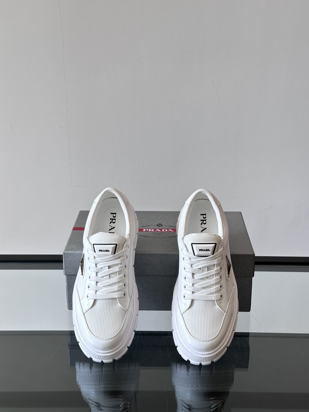 Prada/普拉达 男士新款运动休闲鞋，这款运动鞋鞋面采用进口小牛皮拼接透气网面，外侧饰以P家经典金属三