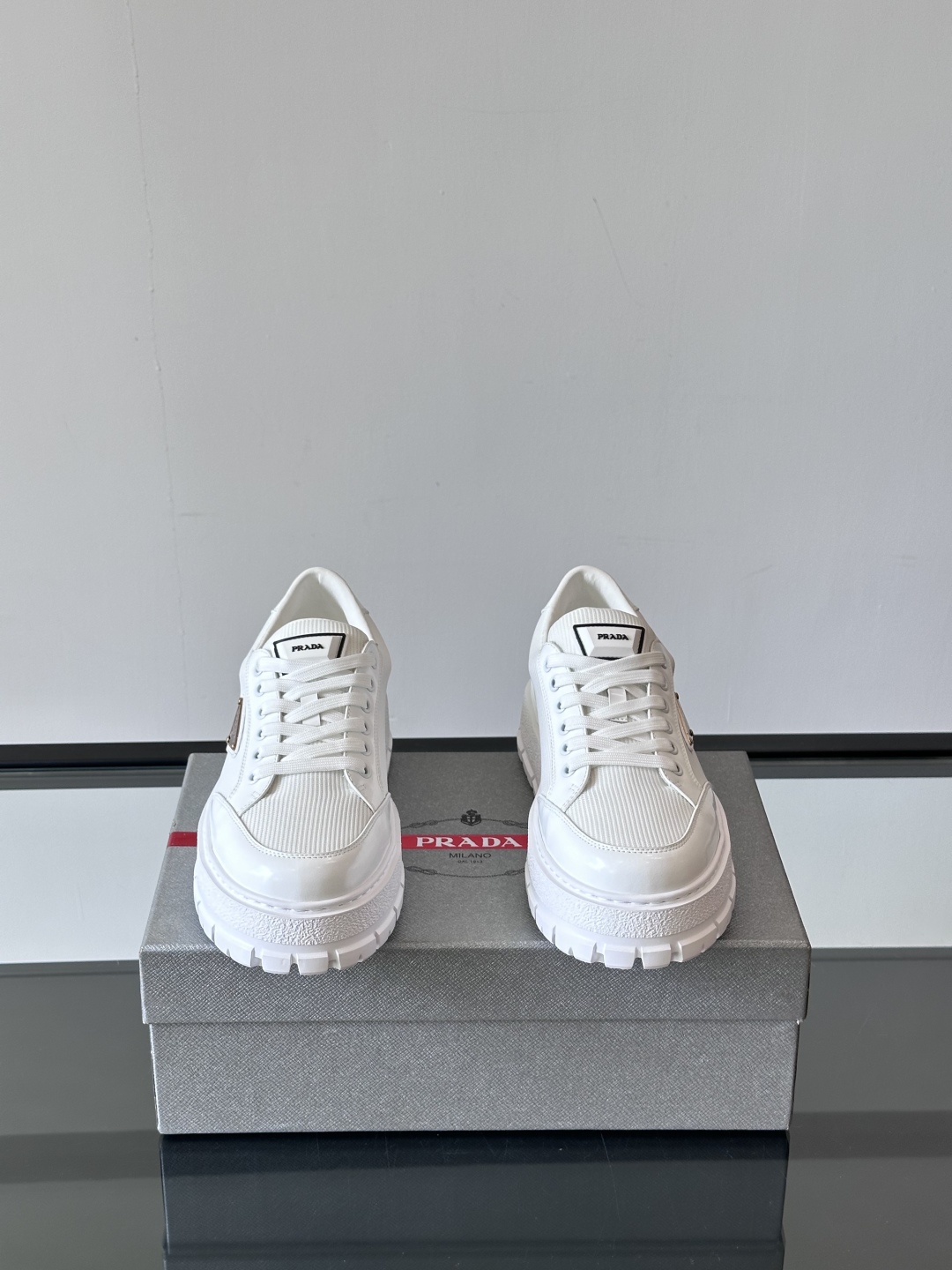 Prada/普拉达 男士新款运动休闲鞋，这款运动鞋鞋面采用进口小牛皮拼接透气网面，外侧饰以P家经典金属三