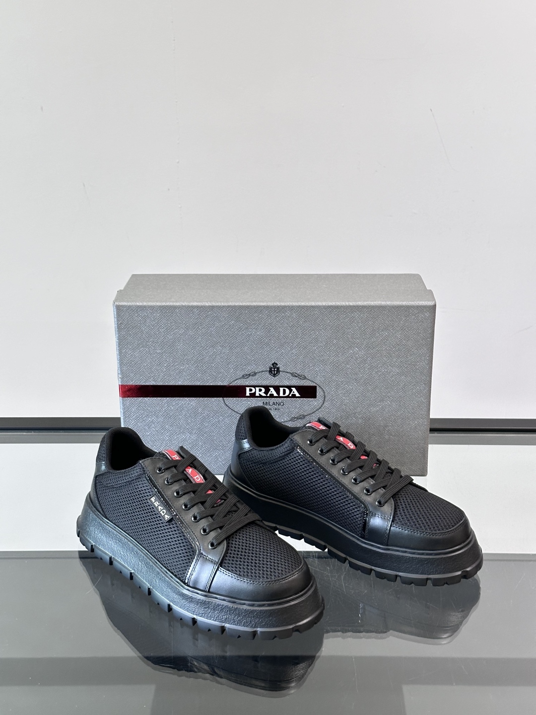 Prada/普拉达 男士新款运动休闲鞋，这款运动鞋鞋面采用进口小牛皮拼接透气网面，透气网面内里。垫脚牛皮