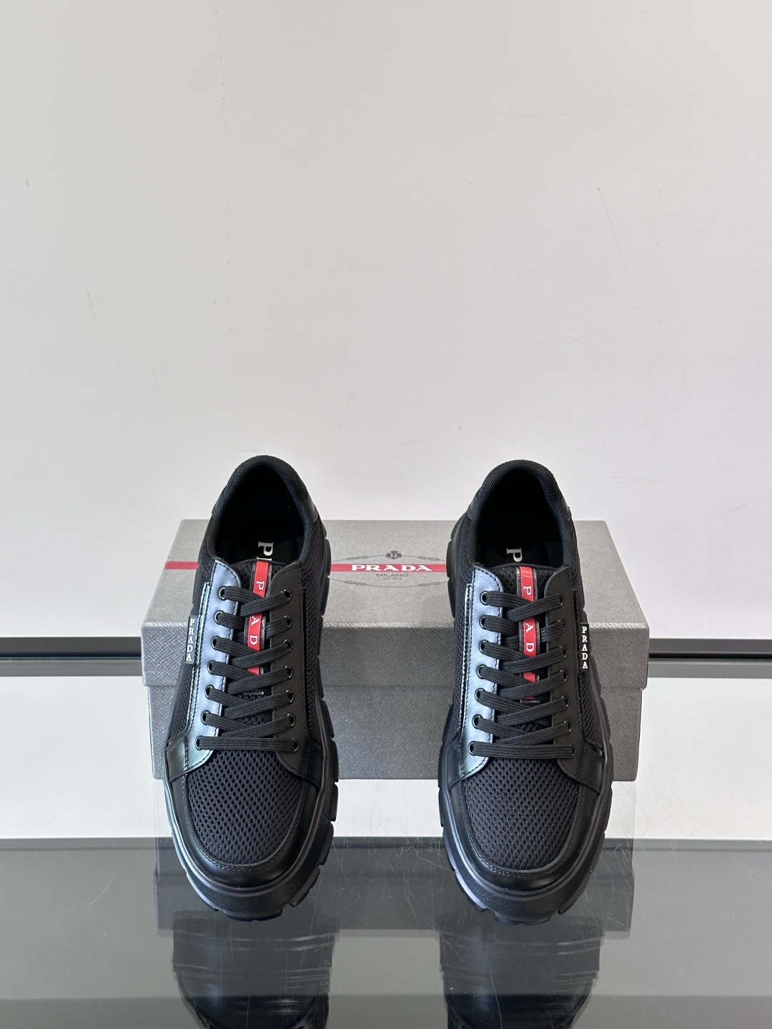 Prada/普拉达 男士新款运动休闲鞋，这款运动鞋鞋面采用进口小牛皮拼接透气网面，透气网面内里。垫脚牛皮