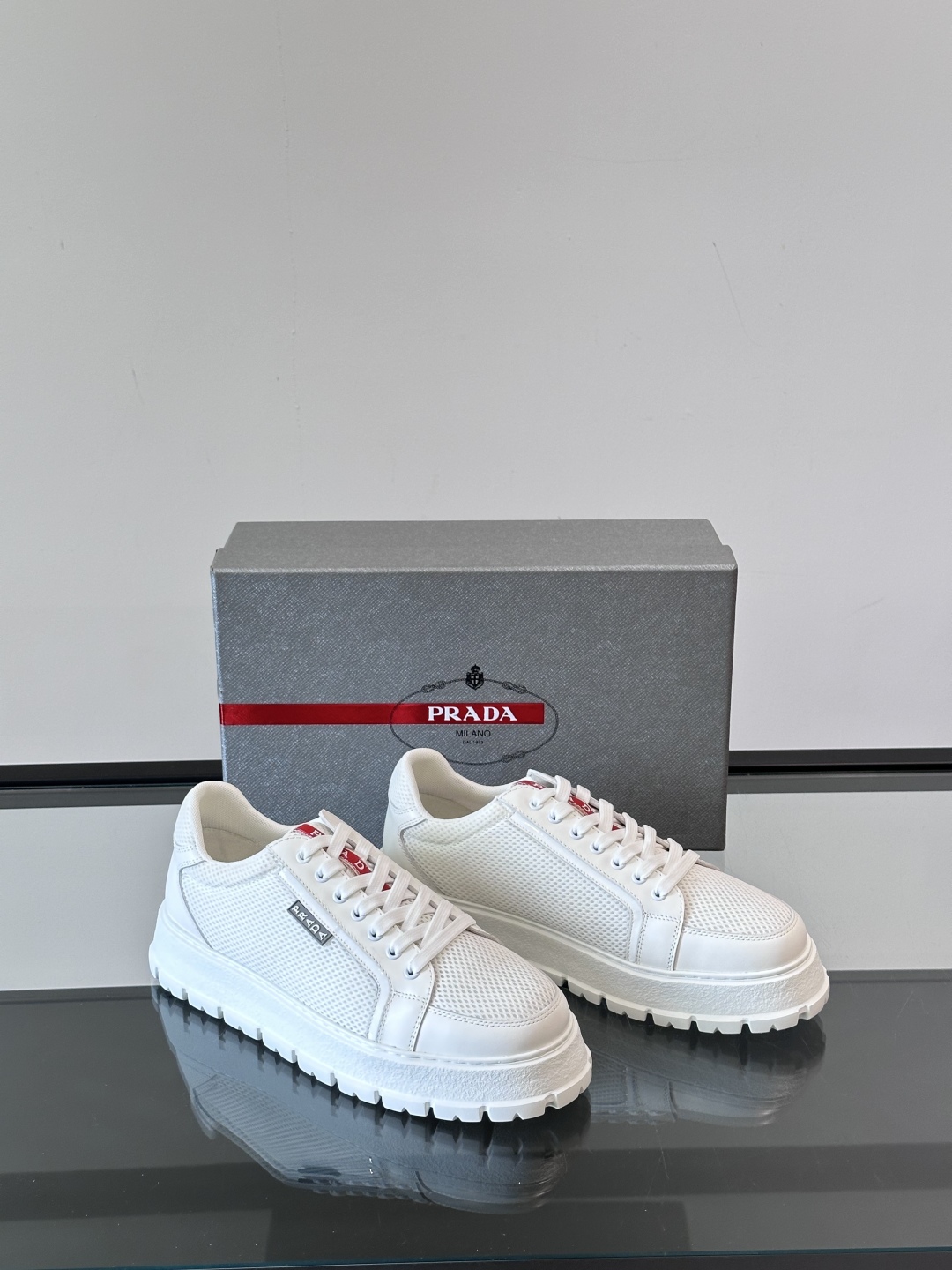 Prada/普拉达 男士新款运动休闲鞋，这款运动鞋鞋面采用进口小牛皮拼接透气网面，透气网面内里。垫脚牛皮