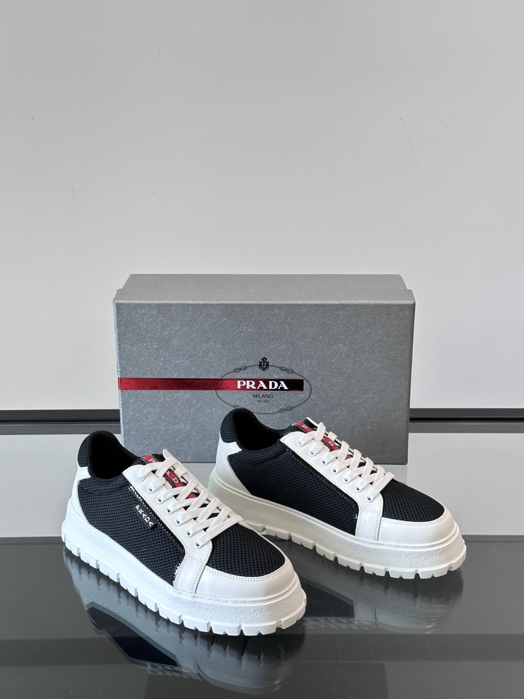 Prada/普拉达 男士新款运动休闲鞋，这款运动鞋鞋面采用进口小牛皮拼接透气网面，透气网面内里。垫脚牛皮