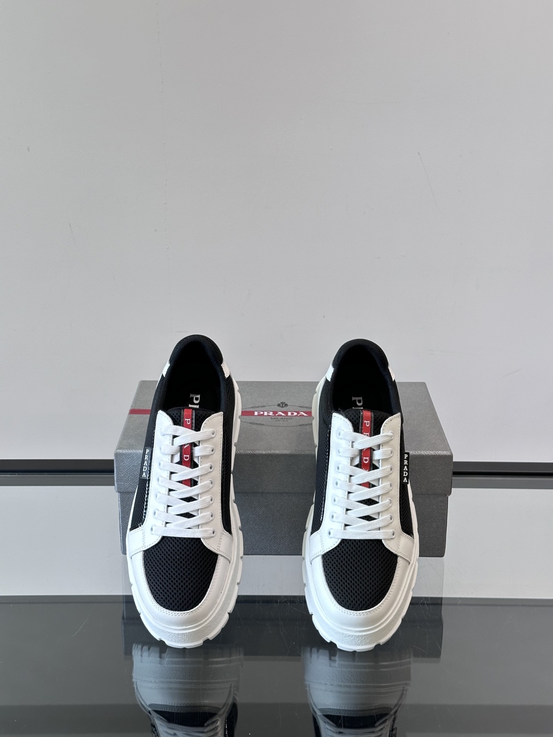 Prada/普拉达 男士新款运动休闲鞋，这款运动鞋鞋面采用进口小牛皮拼接透气网面，透气网面内里。垫脚牛皮