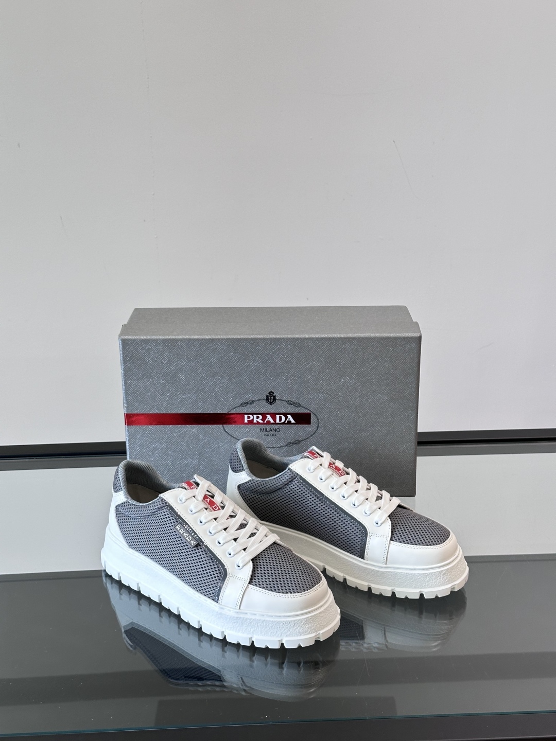 Prada/普拉达 男士新款运动休闲鞋，这款运动鞋鞋面采用进口小牛皮拼接透气网面，透气网面内里。垫脚牛皮