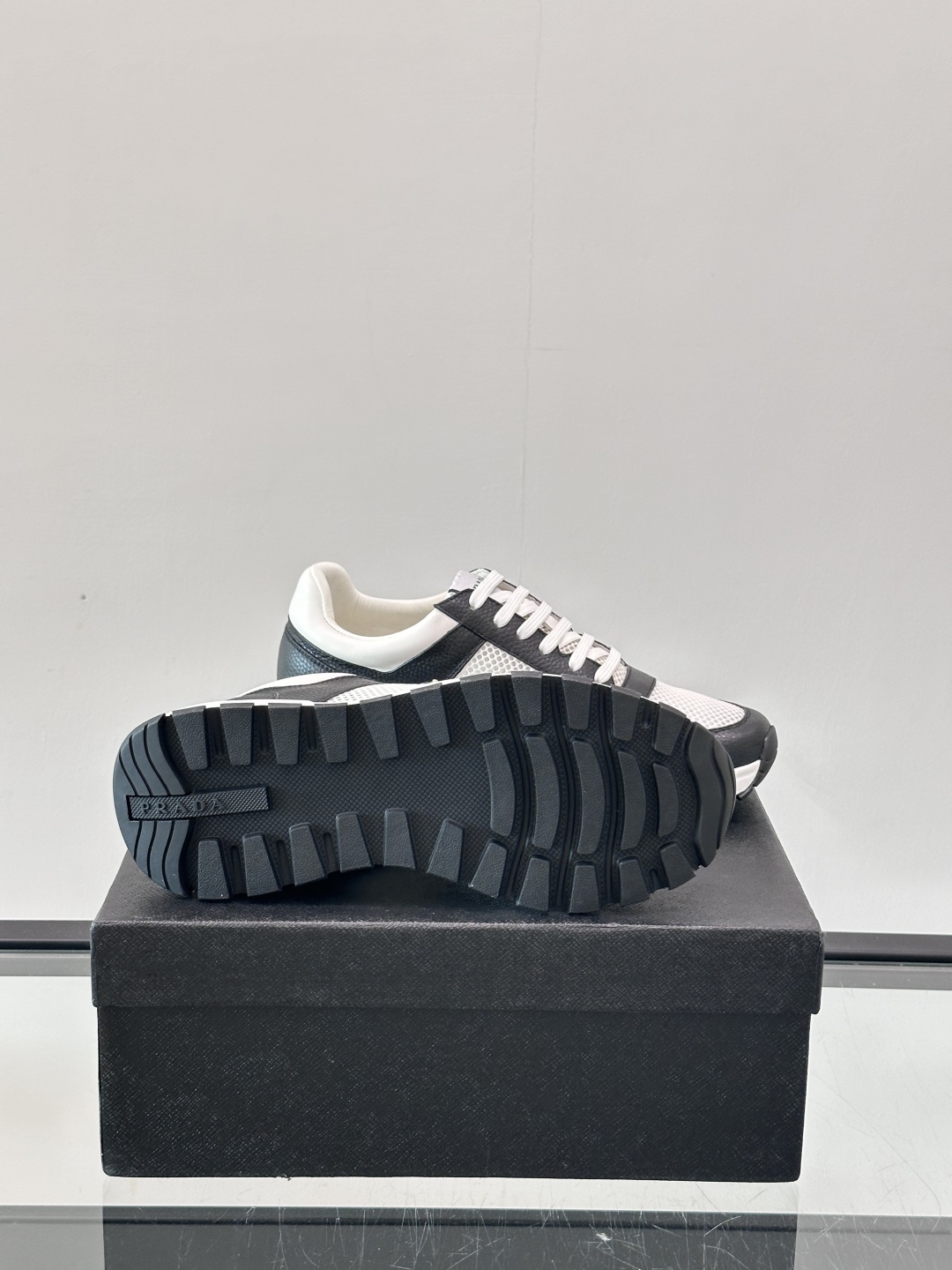 Prada/普拉达 男士新款运动休闲鞋，这款运动鞋鞋面采用进口小牛皮拼接透气网面，外侧饰以P家经典金属三