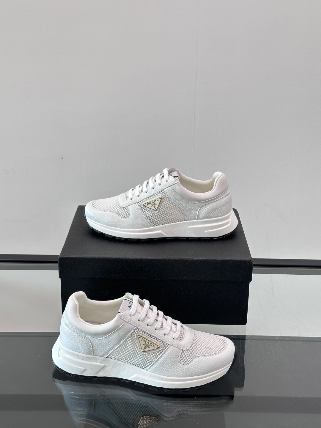 Prada/普拉达 男士新款运动休闲鞋，这款运动鞋鞋面采用进口小牛皮拼接透气网面，外侧饰以P家经典金属三