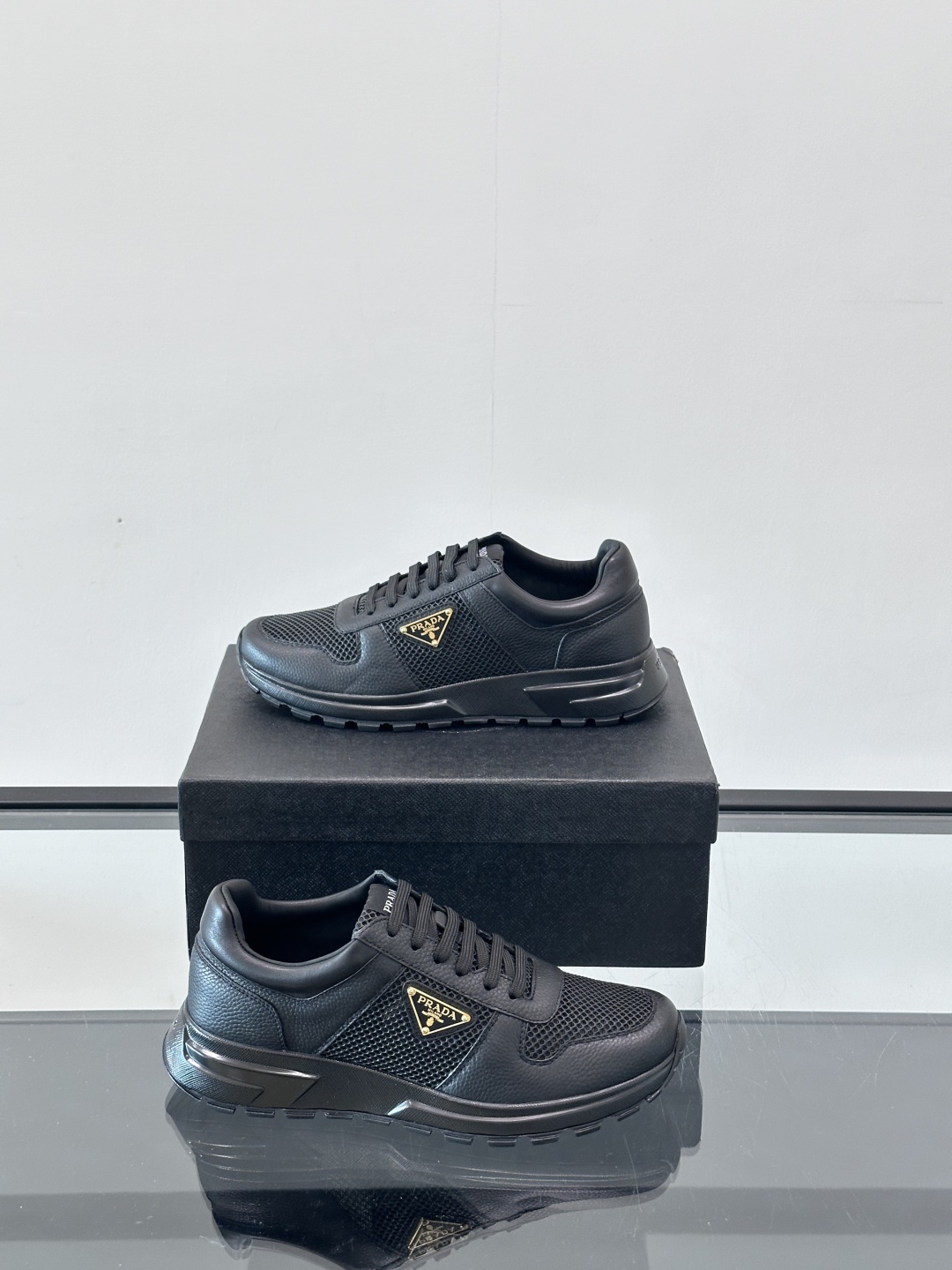 Prada/普拉达 男士新款运动休闲鞋，这款运动鞋鞋面采用进口小牛皮拼接透气网面，外侧饰以P家经典金属三
