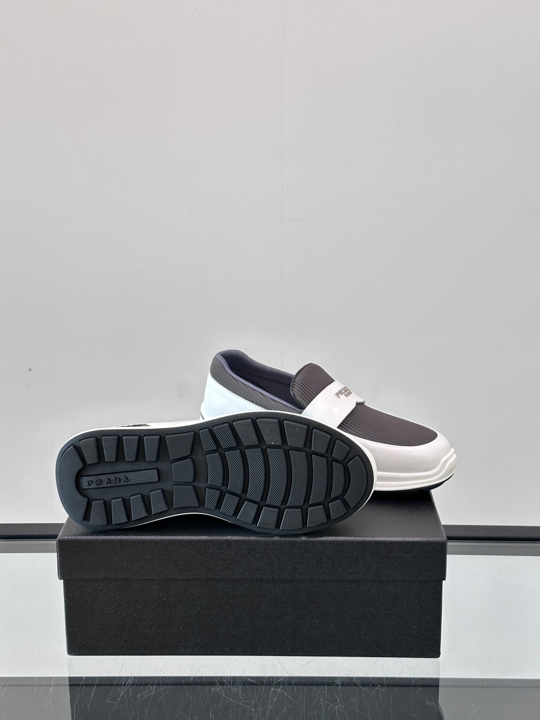 Prada/普拉达 男士新款一脚蹬懒人休闲鞋👟这款运动鞋采用光滑小牛皮革和摔纹牛皮拼接鞋面，一脚蹬乐福鞋