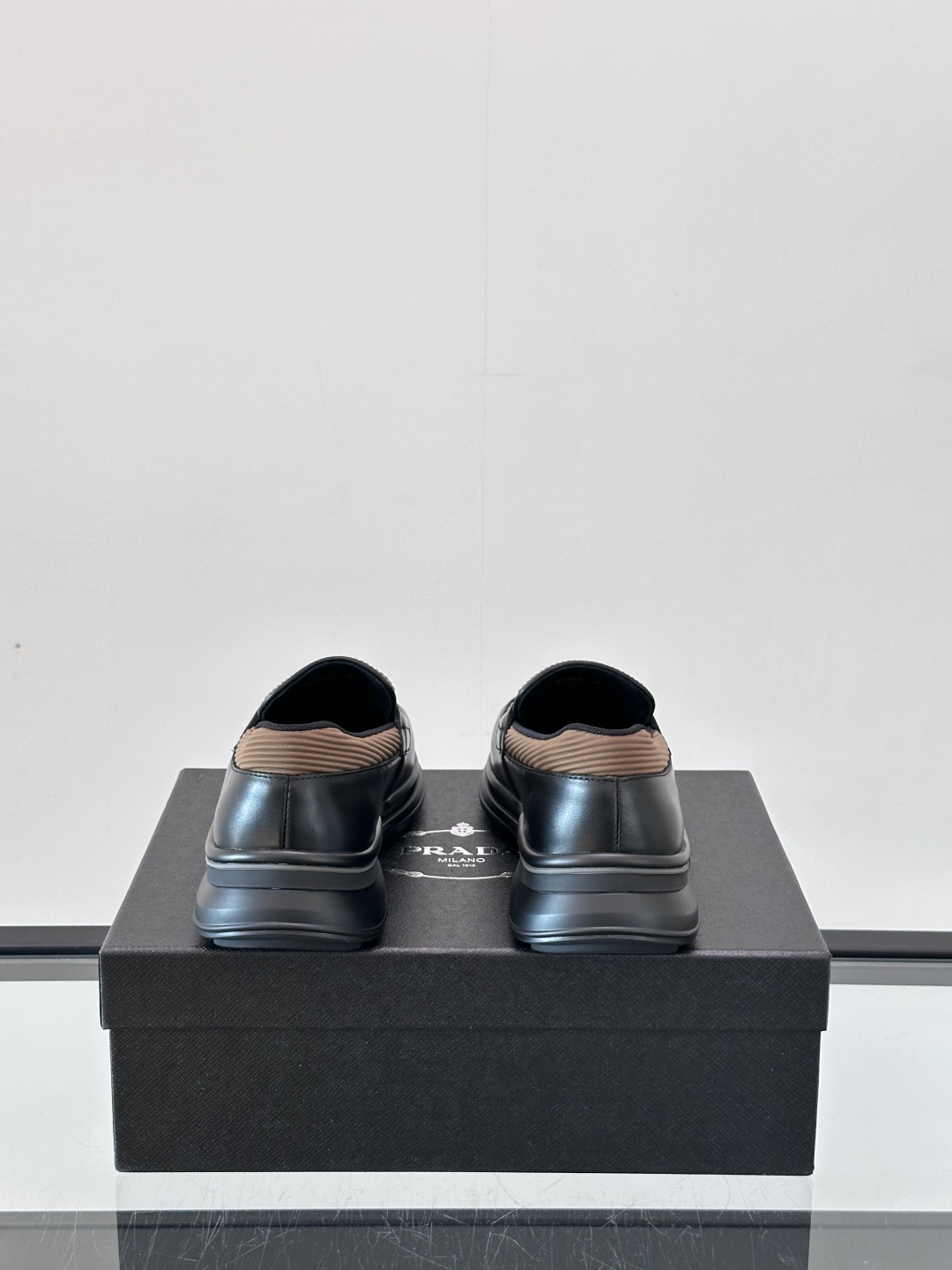 Prada/普拉达 男士新款一脚蹬懒人休闲鞋👟这款运动鞋采用光滑小牛皮革和摔纹牛皮拼接鞋面，一脚蹬乐福鞋
