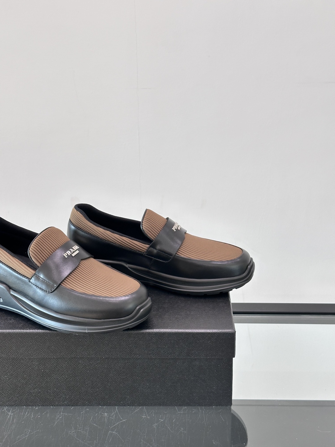 Prada/普拉达 男士新款一脚蹬懒人休闲鞋👟这款运动鞋采用光滑小牛皮革和摔纹牛皮拼接鞋面，一脚蹬乐福鞋