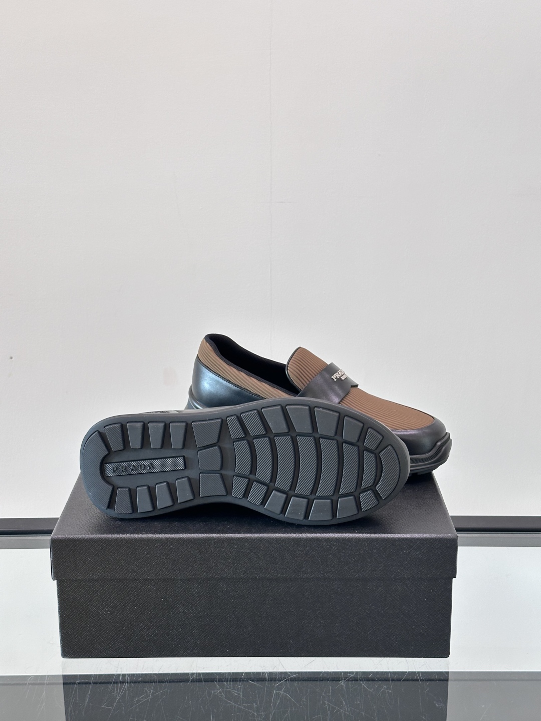 Prada/普拉达 男士新款一脚蹬懒人休闲鞋👟这款运动鞋采用光滑小牛皮革和摔纹牛皮拼接鞋面，一脚蹬乐福鞋