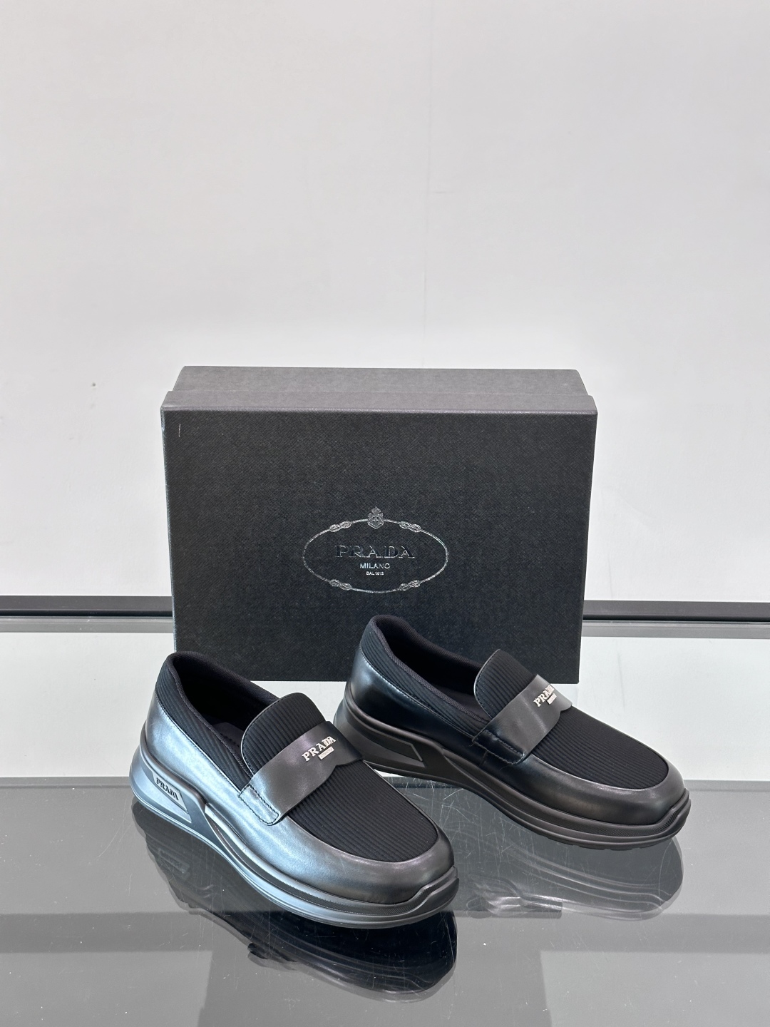 Prada/普拉达 男士新款一脚蹬懒人休闲鞋👟这款运动鞋采用光滑小牛皮革和摔纹牛皮拼接鞋面，一脚蹬乐福鞋