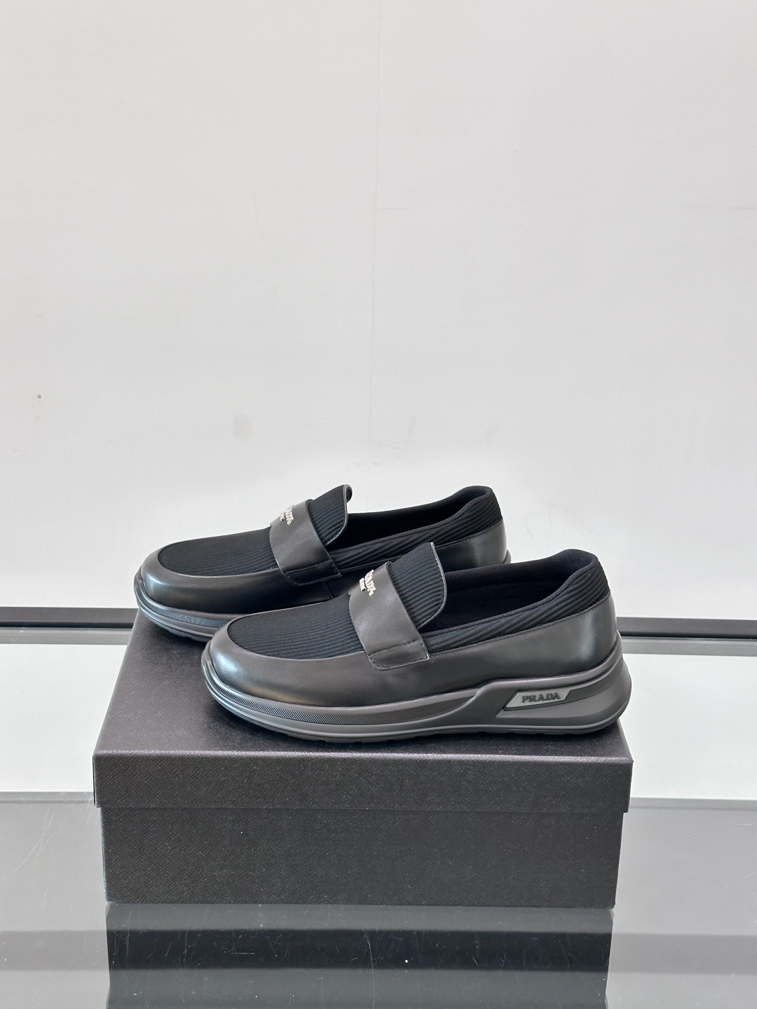 Prada/普拉达 男士新款一脚蹬懒人休闲鞋👟这款运动鞋采用光滑小牛皮革和摔纹牛皮拼接鞋面，一脚蹬乐福鞋