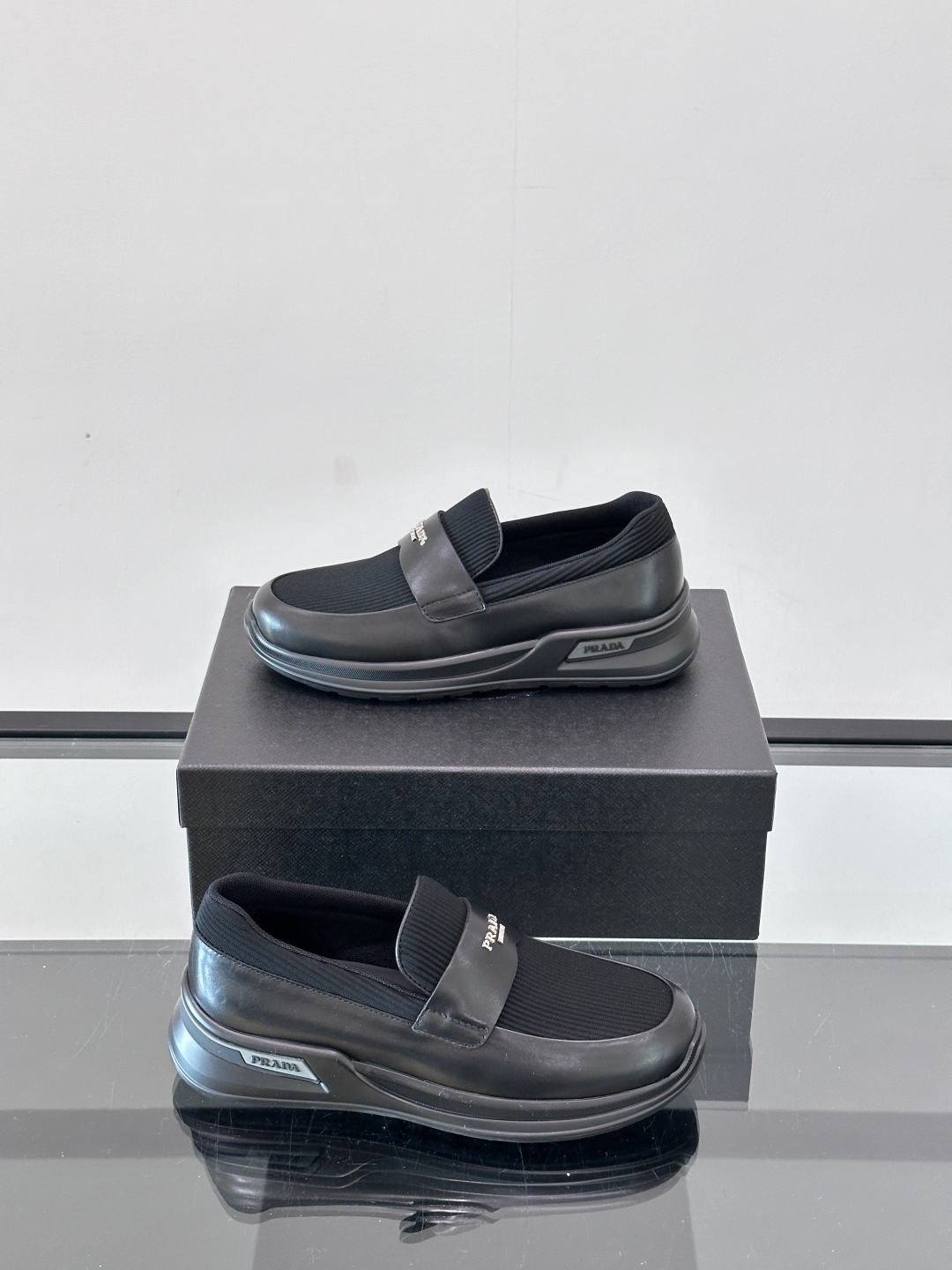 Prada/普拉达 男士新款一脚蹬懒人休闲鞋👟这款运动鞋采用光滑小牛皮革和摔纹牛皮拼接鞋面，一脚蹬乐福鞋