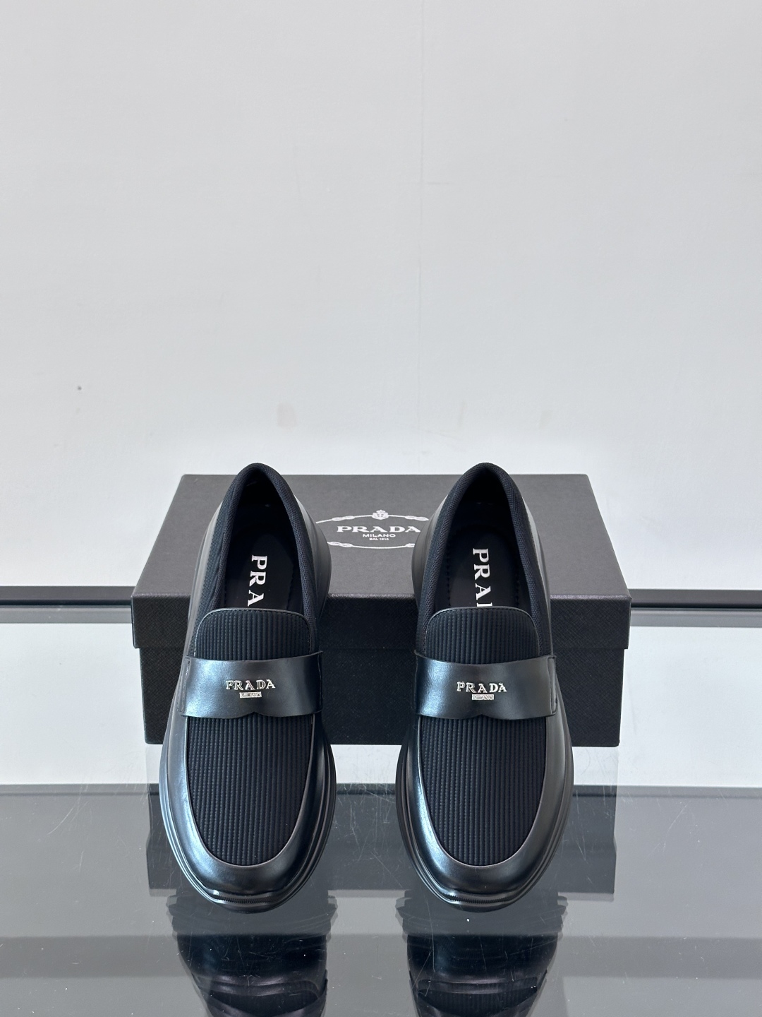 Prada/普拉达 男士新款一脚蹬懒人休闲鞋👟这款运动鞋采用光滑小牛皮革和摔纹牛皮拼接鞋面，一脚蹬乐福鞋