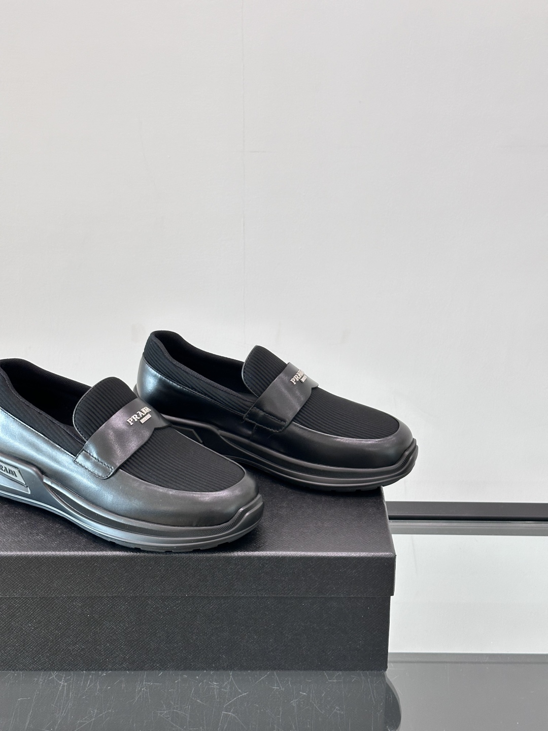 Prada/普拉达 男士新款一脚蹬懒人休闲鞋👟这款运动鞋采用光滑小牛皮革和摔纹牛皮拼接鞋面，一脚蹬乐福鞋