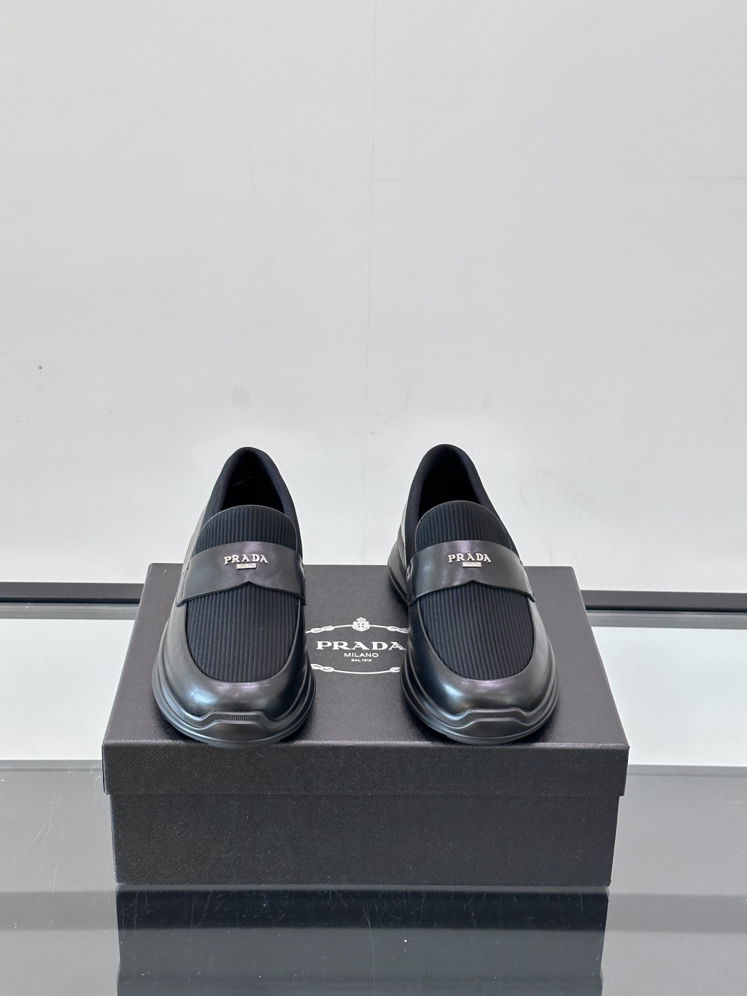 Prada/普拉达 男士新款一脚蹬懒人休闲鞋👟这款运动鞋采用光滑小牛皮革和摔纹牛皮拼接鞋面，一脚蹬乐福鞋