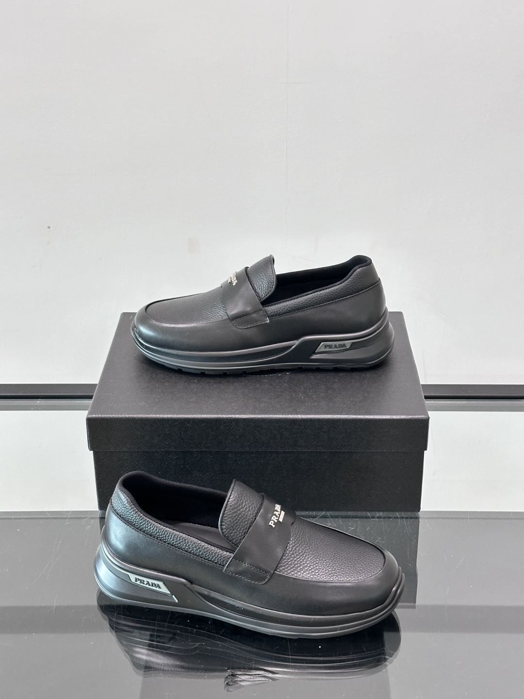 Prada/普拉达 男士新款一脚蹬懒人休闲鞋👟这款运动鞋采用光滑小牛皮革和摔纹牛皮拼接鞋面，一脚蹬乐福鞋