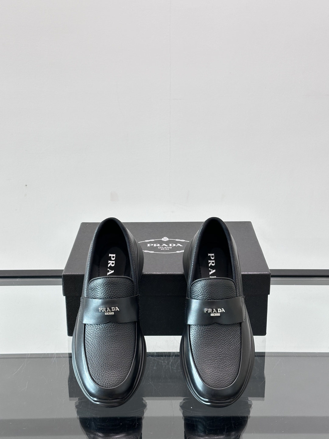 Prada/普拉达 男士新款一脚蹬懒人休闲鞋👟这款运动鞋采用光滑小牛皮革和摔纹牛皮拼接鞋面，一脚蹬乐福鞋