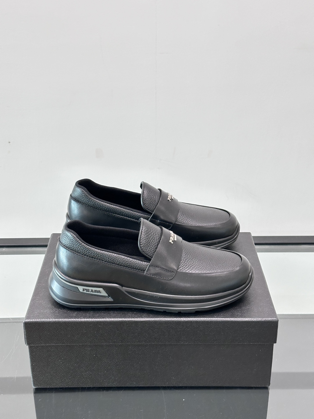 Prada/普拉达 男士新款一脚蹬懒人休闲鞋👟这款运动鞋采用光滑小牛皮革和摔纹牛皮拼接鞋面，一脚蹬乐福鞋