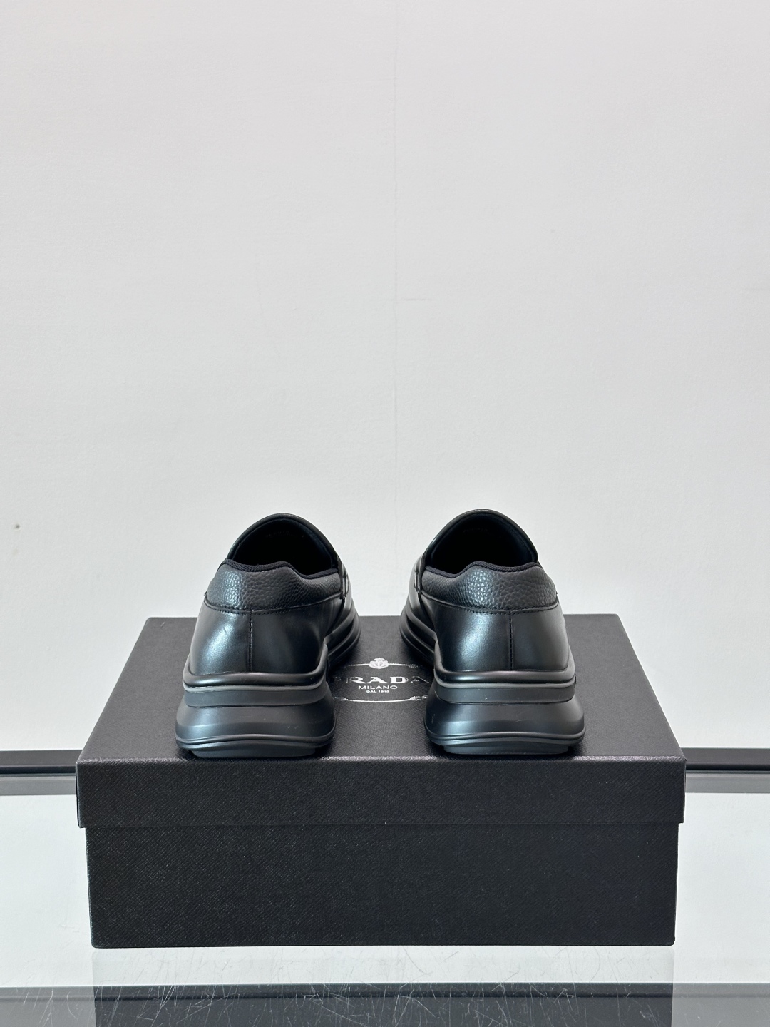 Prada/普拉达 男士新款一脚蹬懒人休闲鞋👟这款运动鞋采用光滑小牛皮革和摔纹牛皮拼接鞋面，一脚蹬乐福鞋
