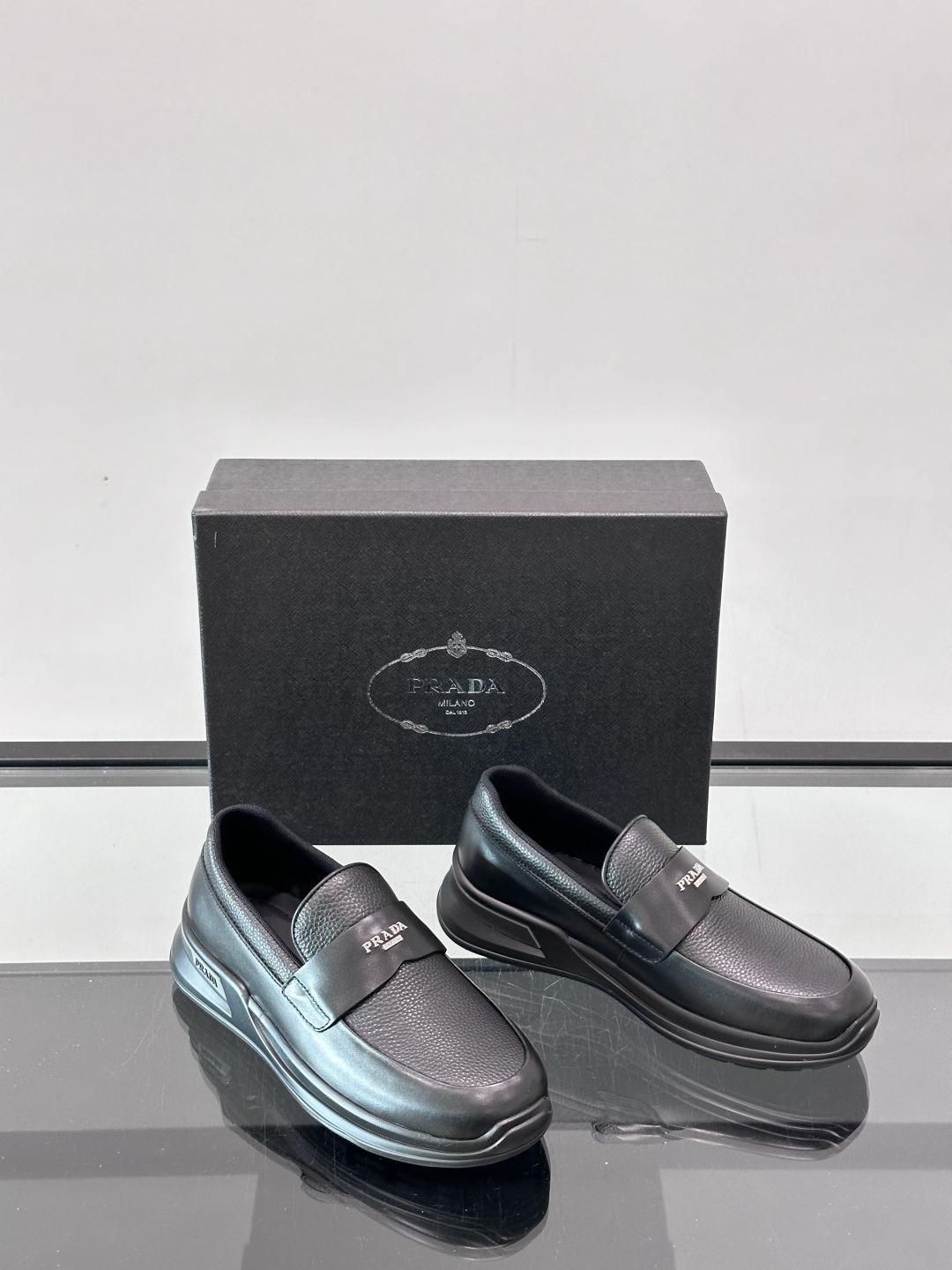Prada/普拉达 男士新款一脚蹬懒人休闲鞋👟这款运动鞋采用光滑小牛皮革和摔纹牛皮拼接鞋面，一脚蹬乐福鞋