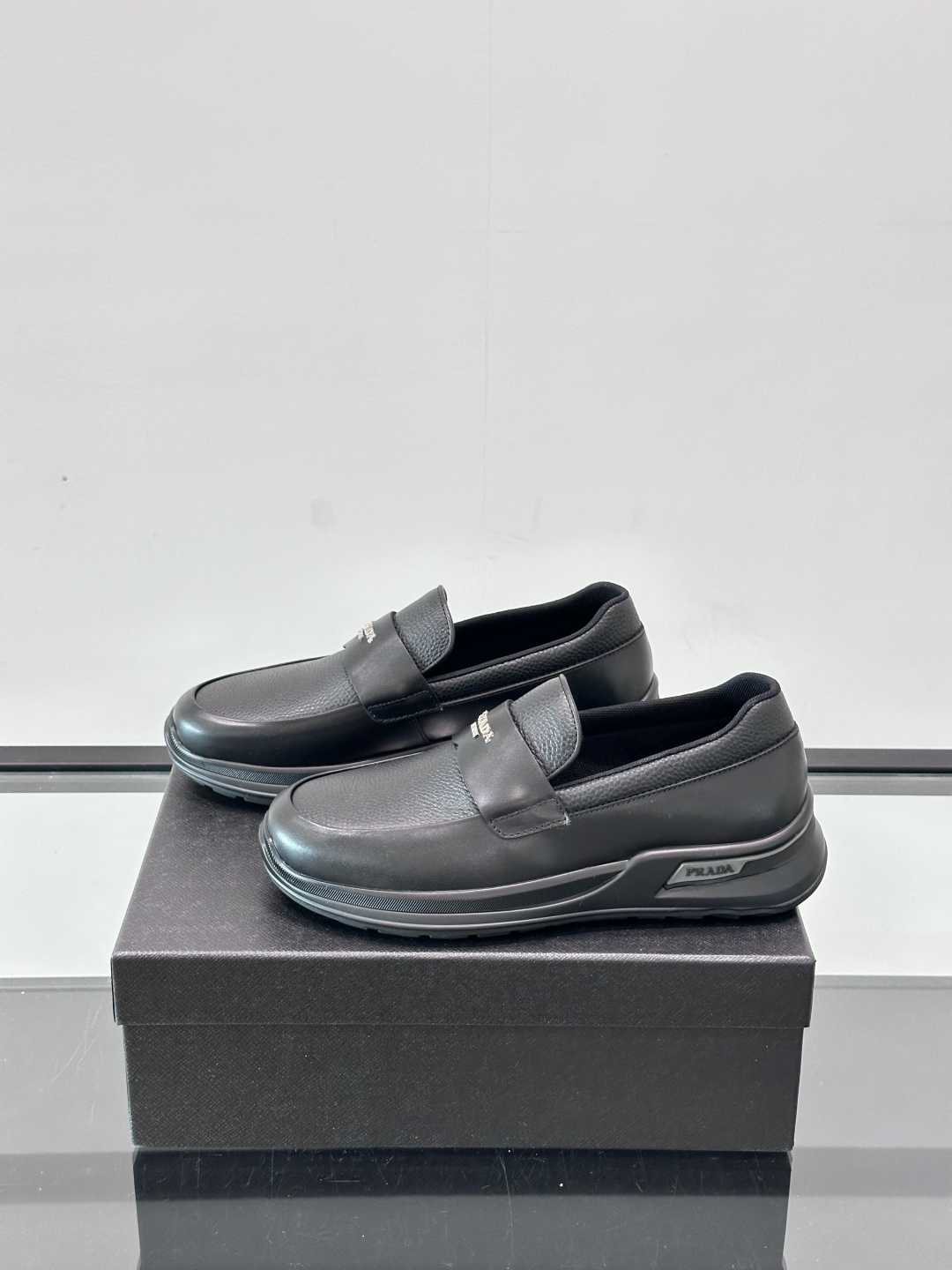Prada/普拉达 男士新款一脚蹬懒人休闲鞋👟这款运动鞋采用光滑小牛皮革和摔纹牛皮拼接鞋面，一脚蹬乐福鞋