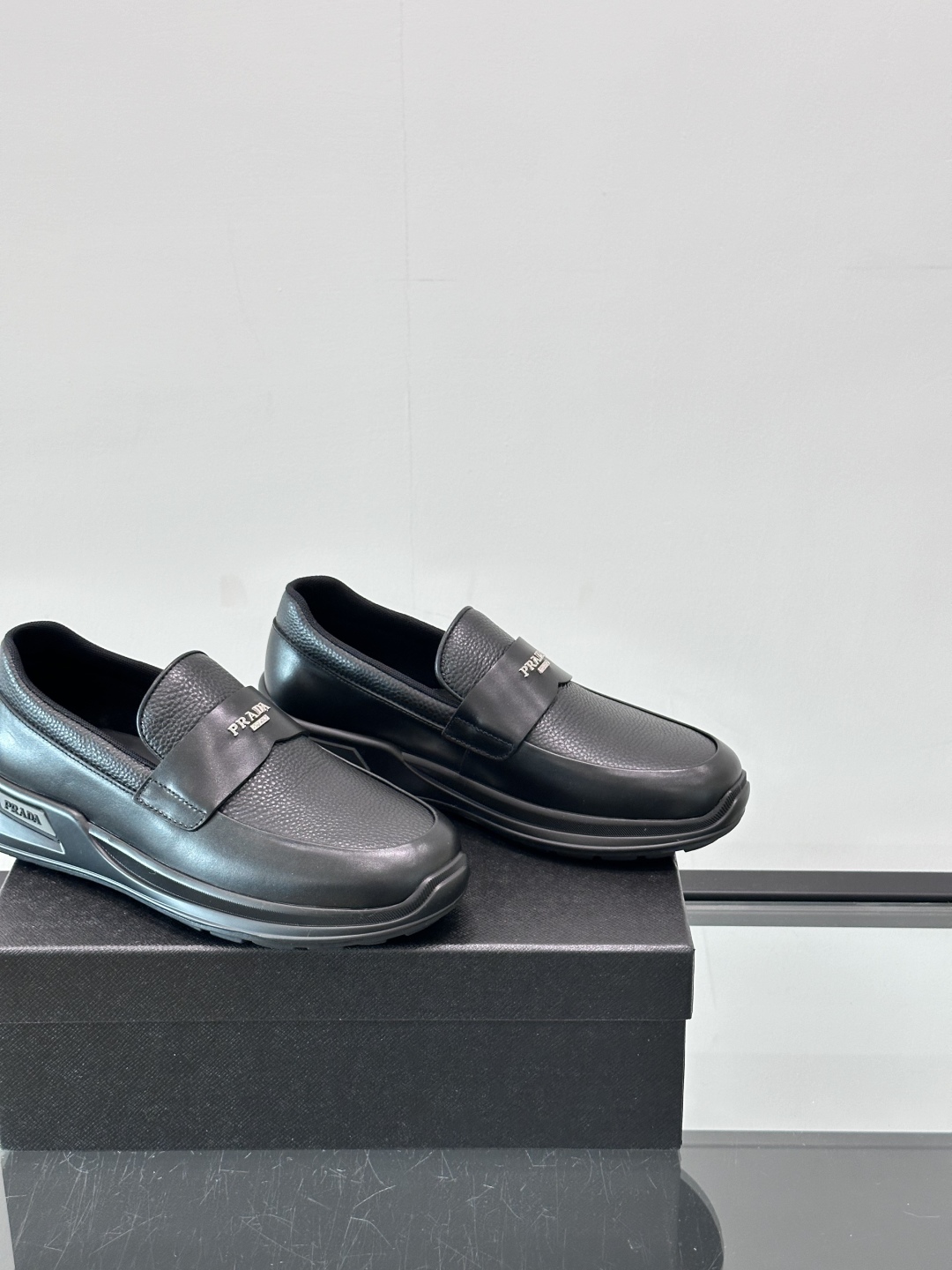 Prada/普拉达 男士新款一脚蹬懒人休闲鞋👟这款运动鞋采用光滑小牛皮革和摔纹牛皮拼接鞋面，一脚蹬乐福鞋
