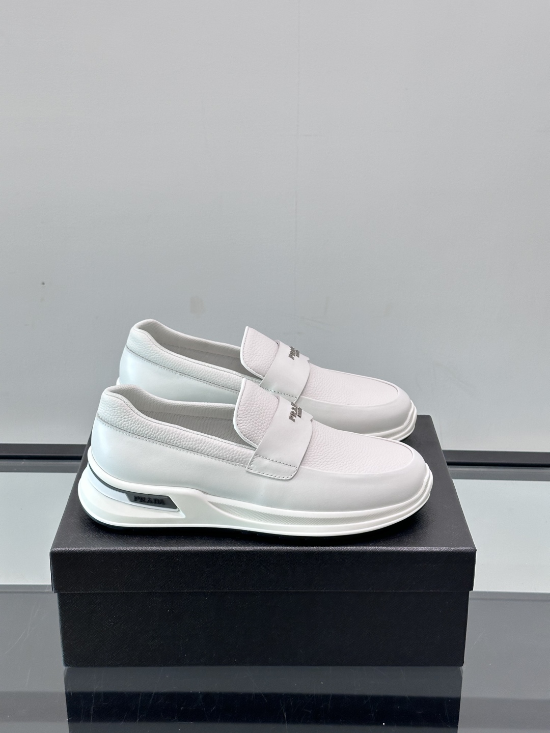 Prada/普拉达 男士新款一脚蹬懒人休闲鞋👟这款运动鞋采用光滑小牛皮革和摔纹牛皮拼接鞋面，一脚蹬乐福鞋