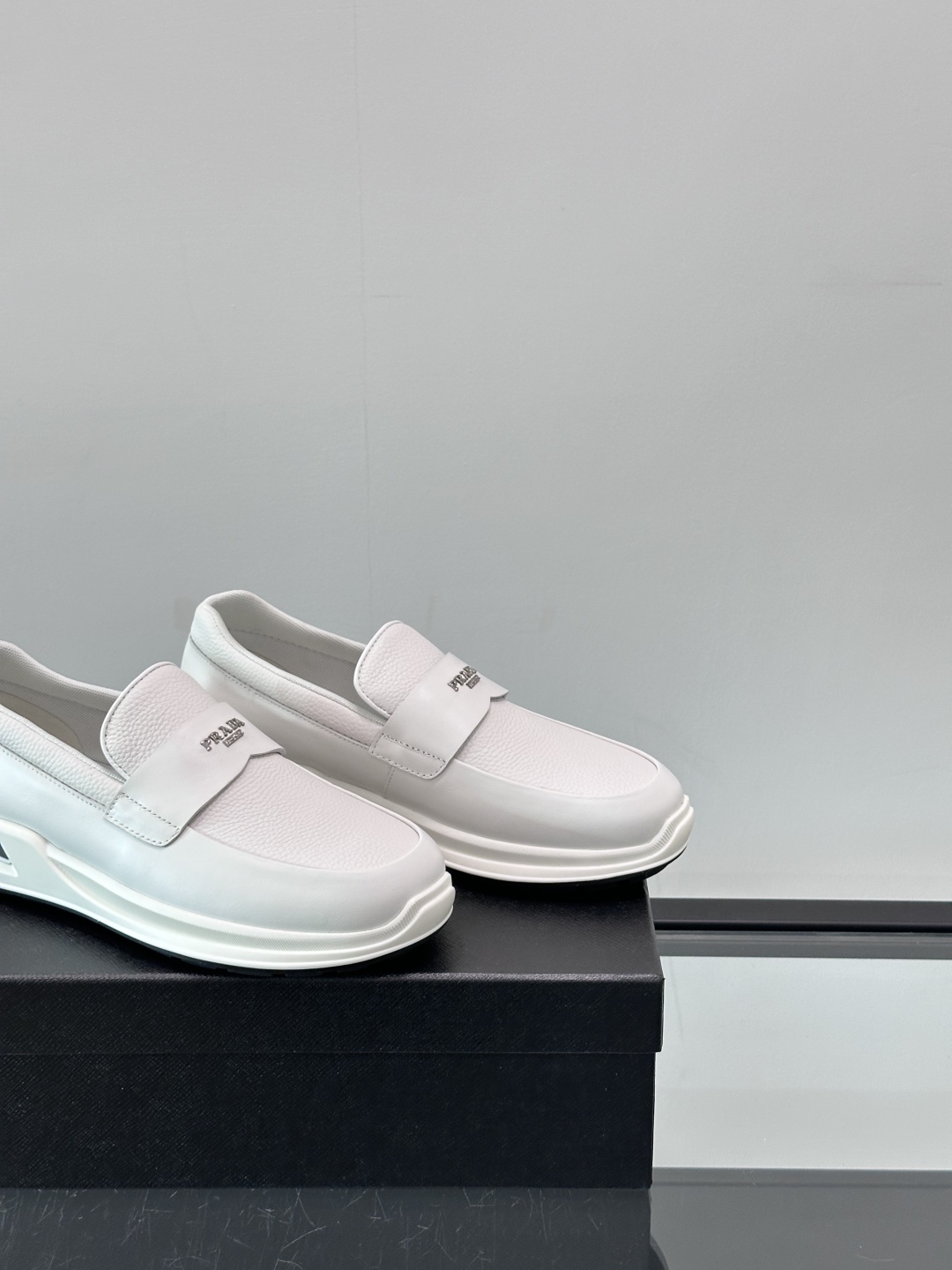 Prada/普拉达 男士新款一脚蹬懒人休闲鞋👟这款运动鞋采用光滑小牛皮革和摔纹牛皮拼接鞋面，一脚蹬乐福鞋