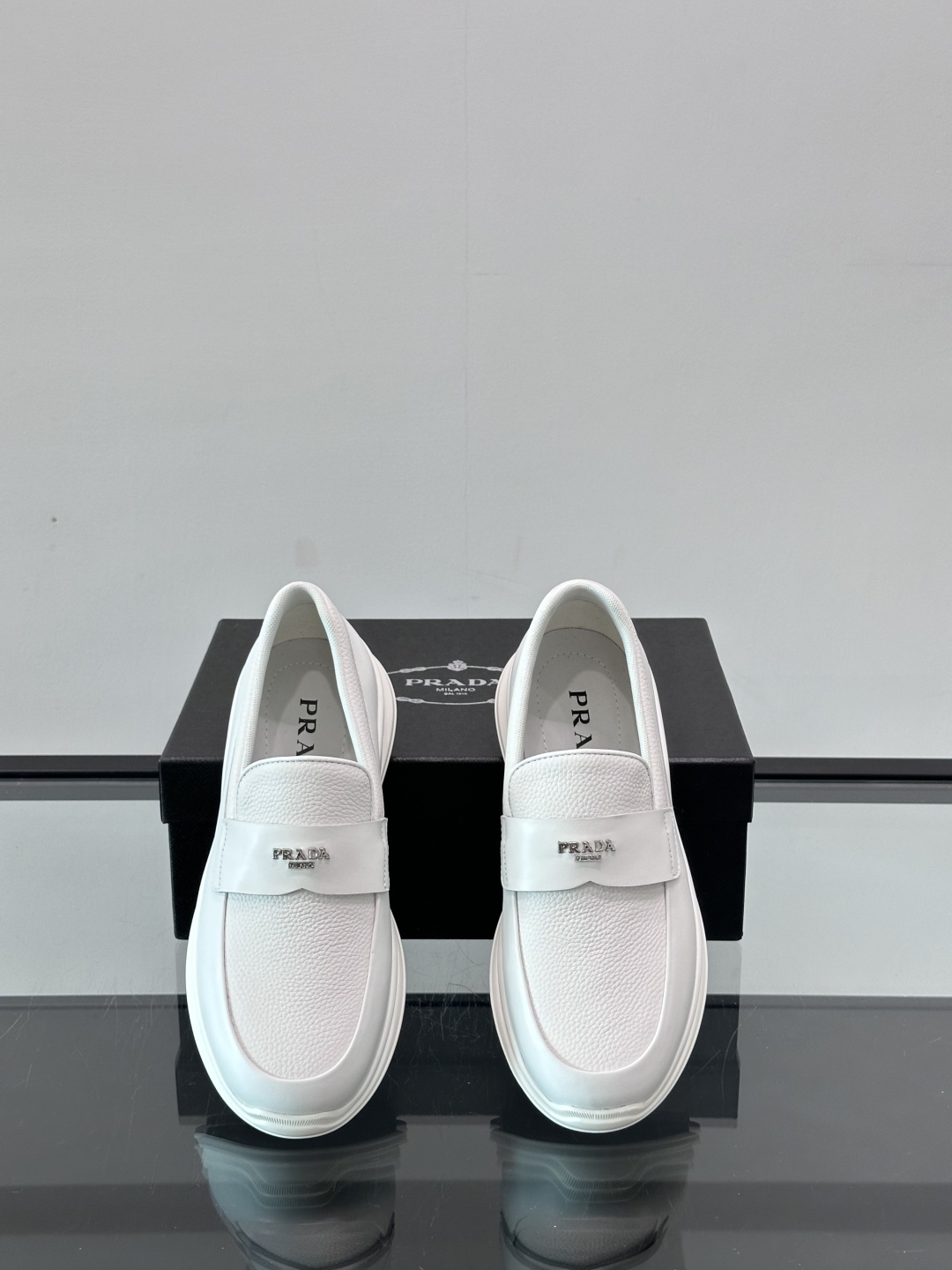 Prada/普拉达 男士新款一脚蹬懒人休闲鞋👟这款运动鞋采用光滑小牛皮革和摔纹牛皮拼接鞋面，一脚蹬乐福鞋