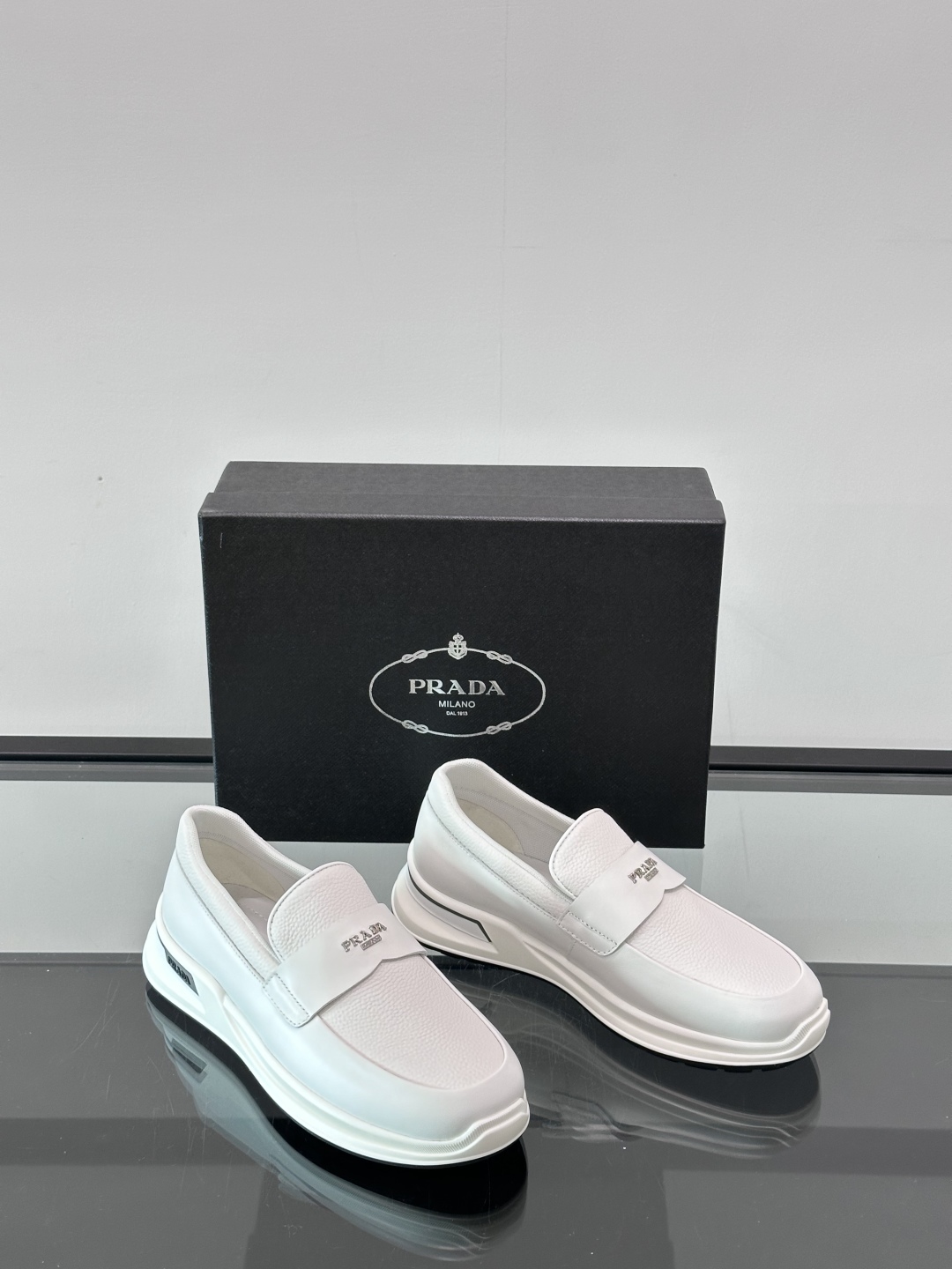Prada/普拉达 男士新款一脚蹬懒人休闲鞋👟这款运动鞋采用光滑小牛皮革和摔纹牛皮拼接鞋面，一脚蹬乐福鞋